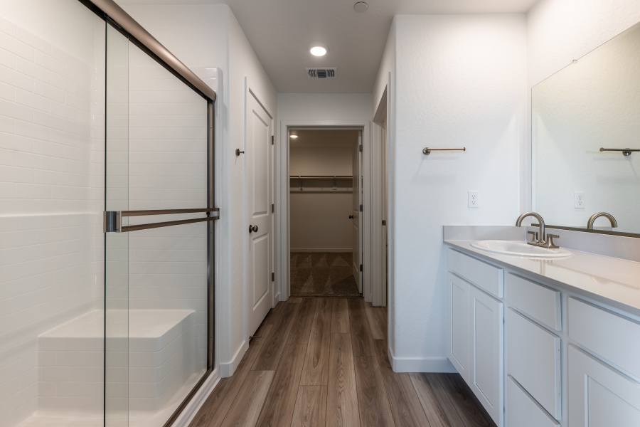 A bathroom with white cabinets.