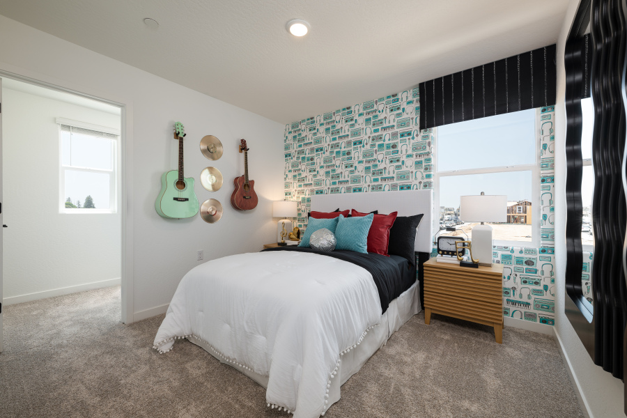 A bedroom with a bed and guitars.