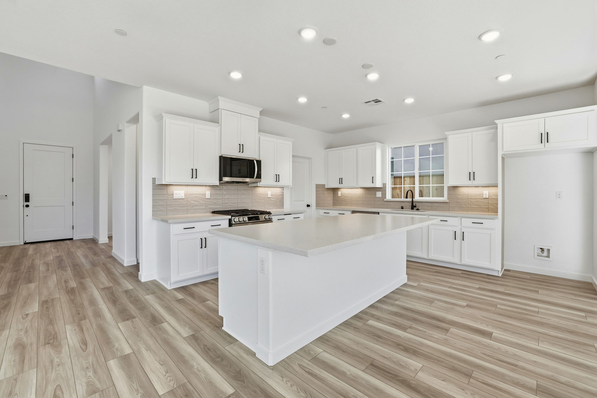 A kitchen with white cabinets.