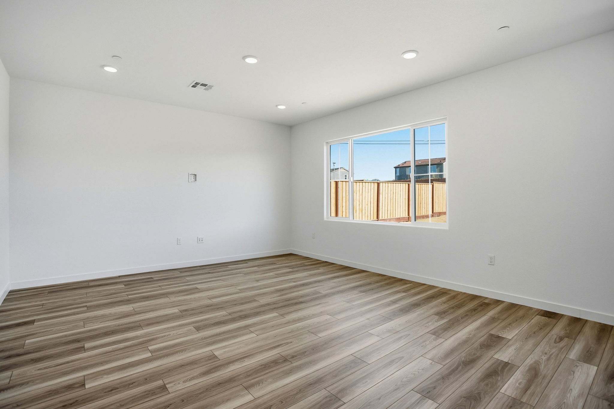 A room with a wood floor and a window.