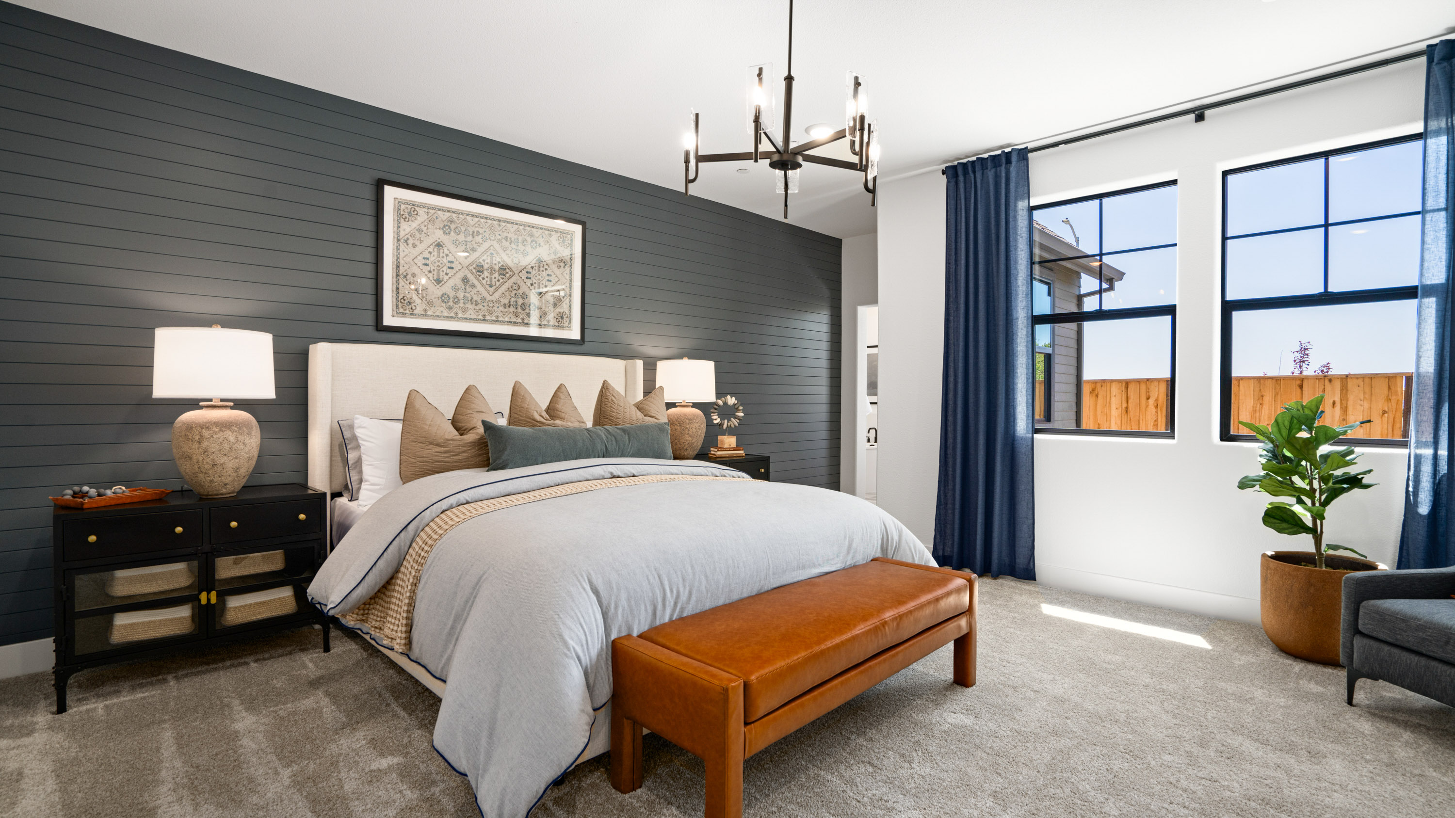 A bedroom with a bed and a bench.