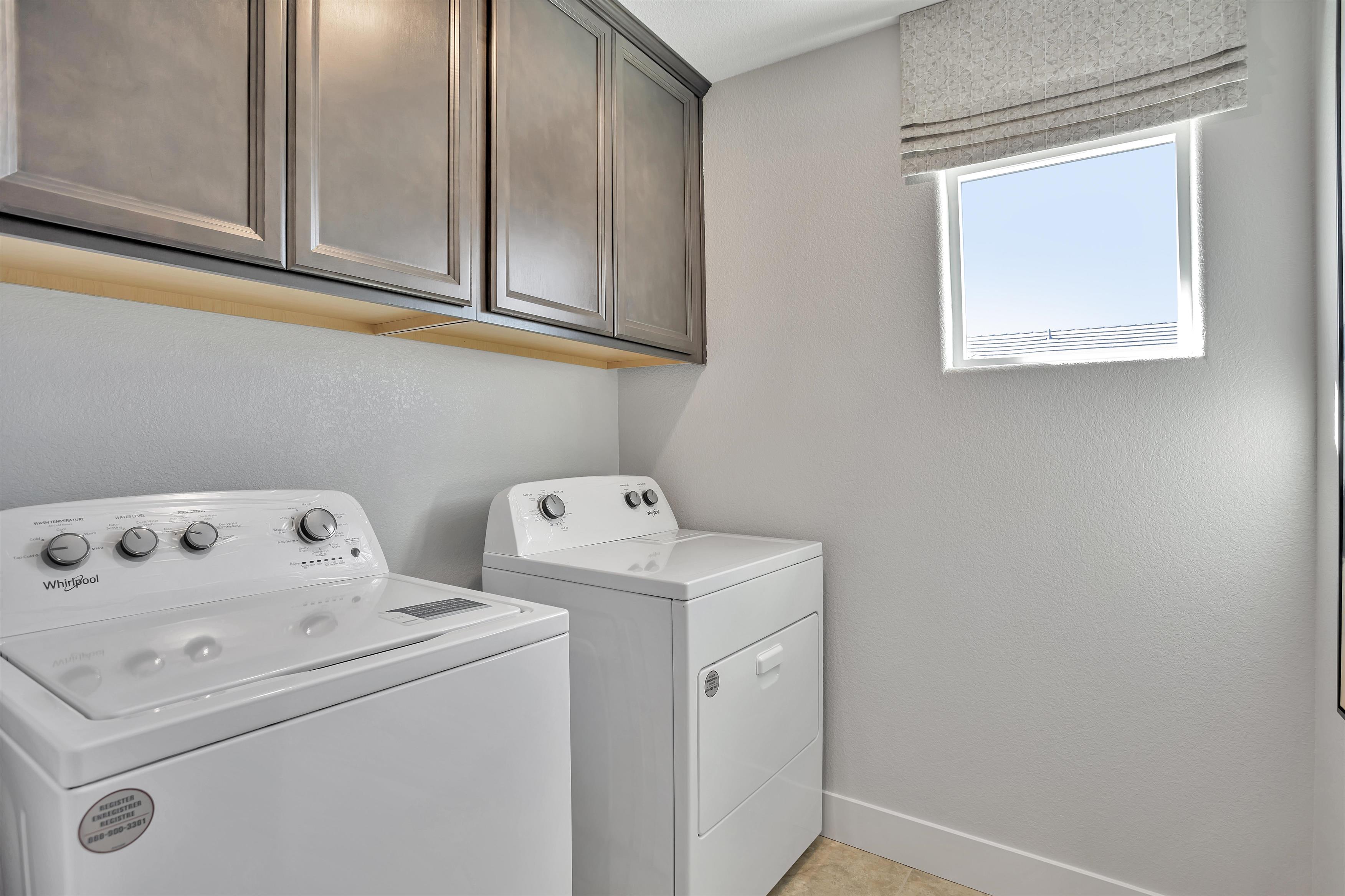 A white washing machine and a white stove in a kitchen.