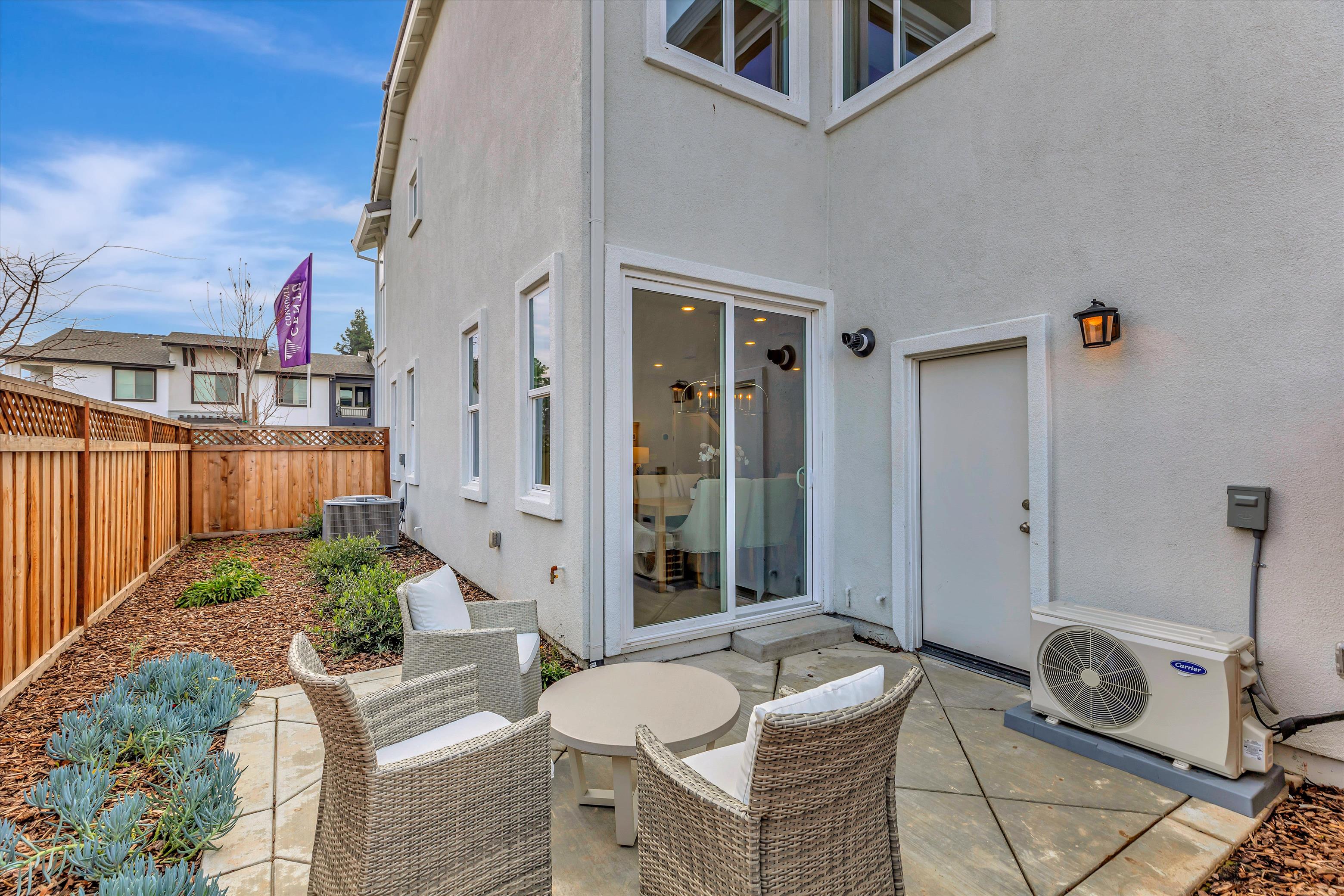 A patio with chairs and a table.