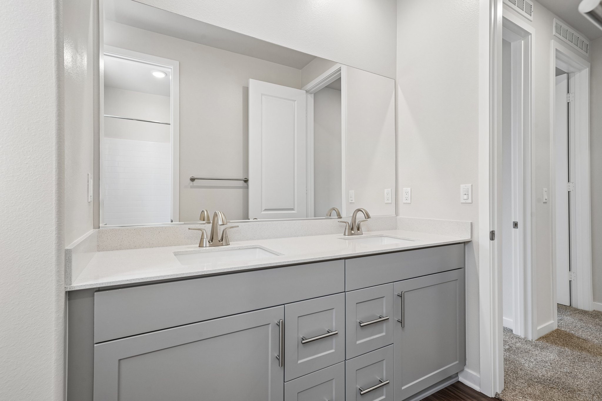 A bathroom with white cabinets.