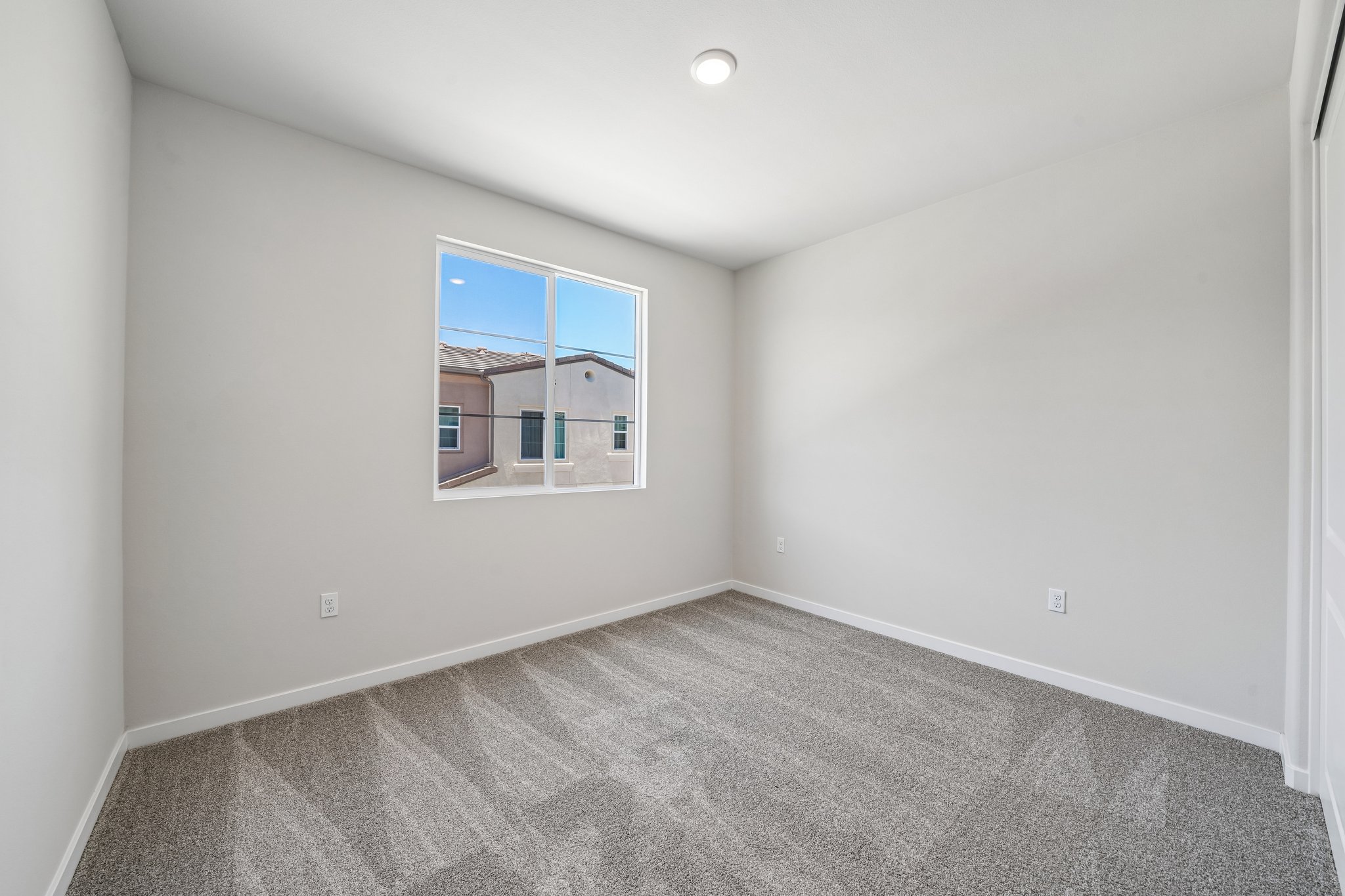 A room with a window and a carpet.