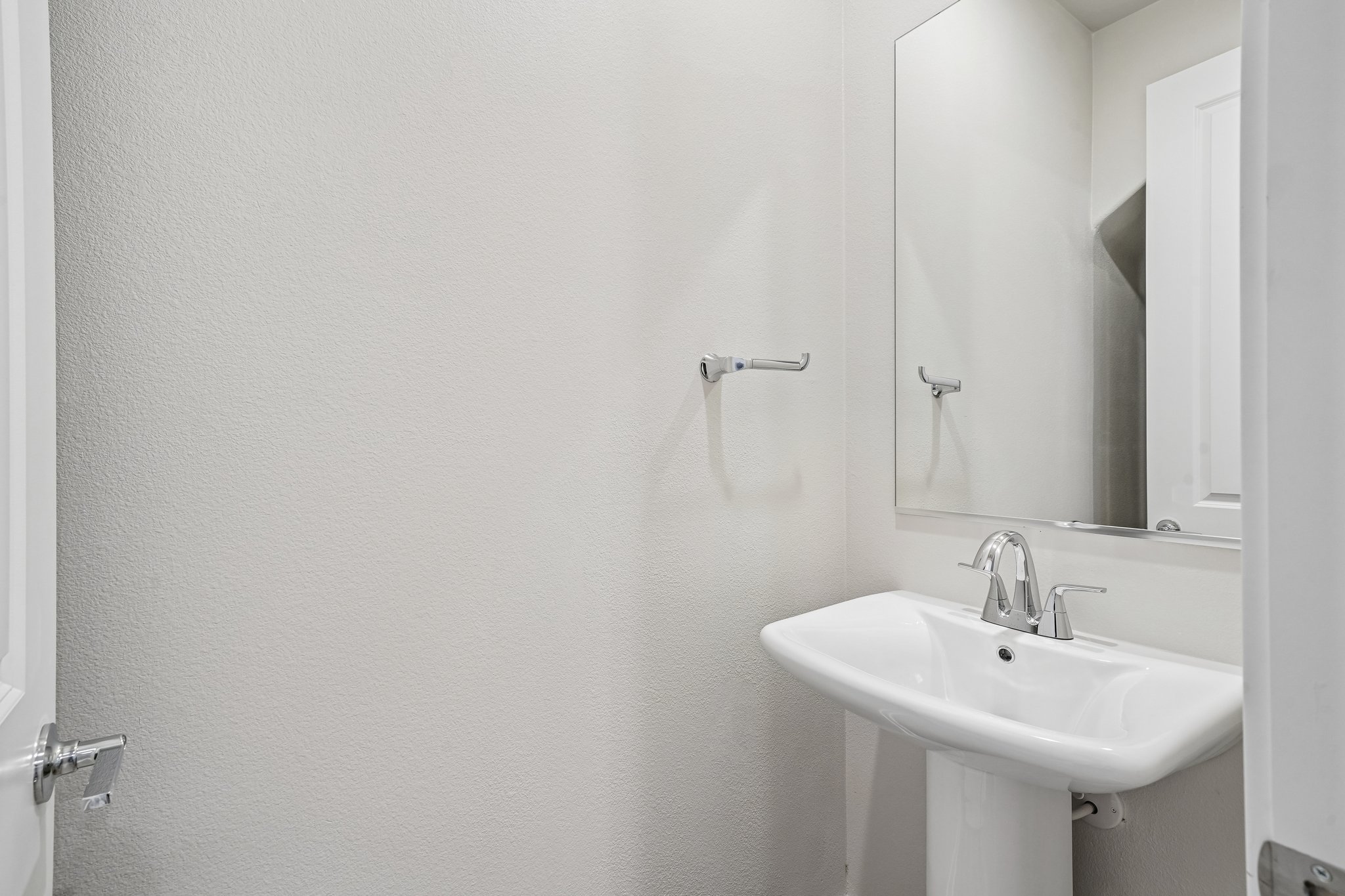 A bathroom with a mirror and sink.