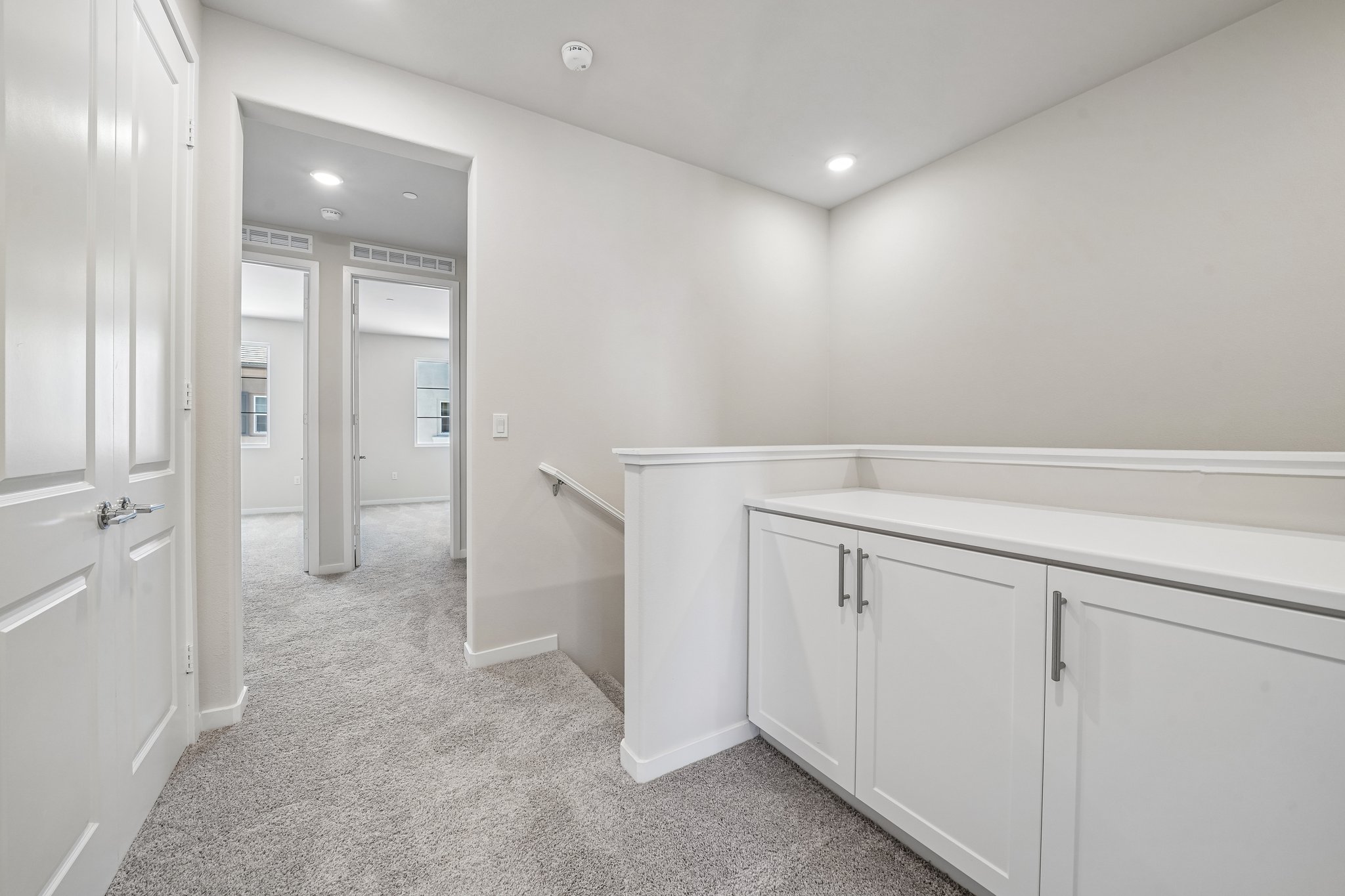 A bathroom with white cabinets.