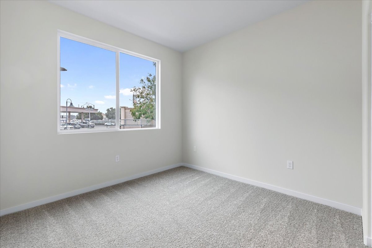 A room with a window and a white wall.