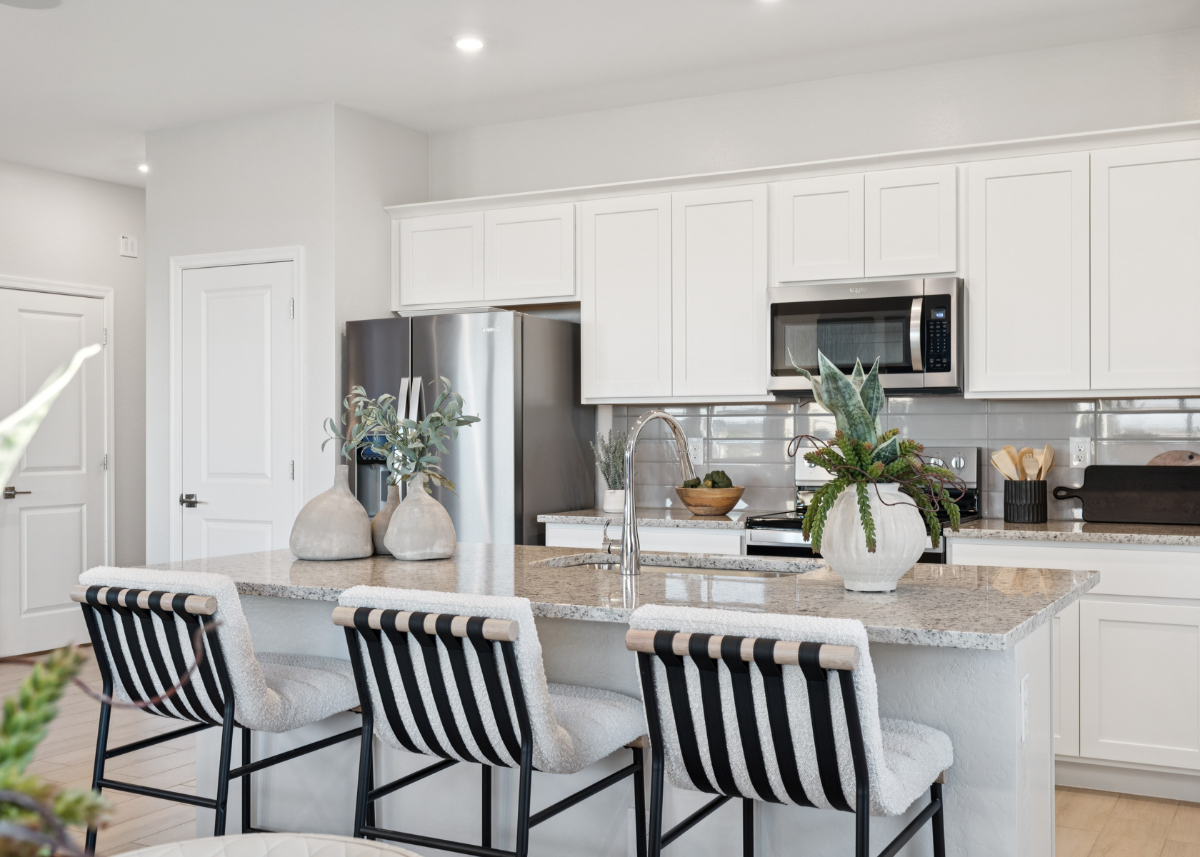 A kitchen with white cabinets.