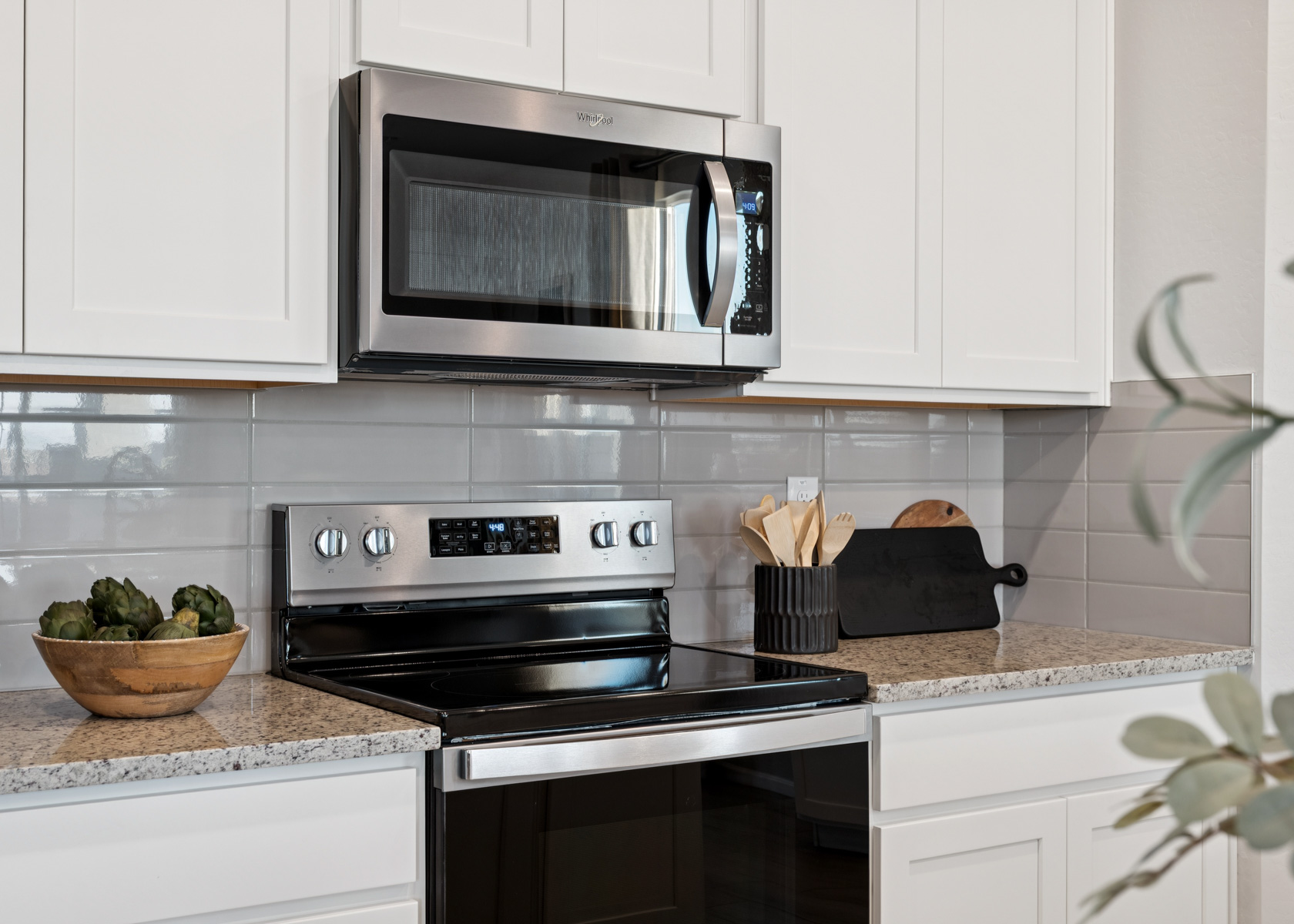 A kitchen with white cabinets.