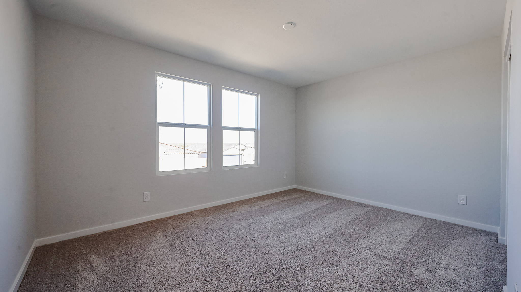 A room with a window and a carpet.