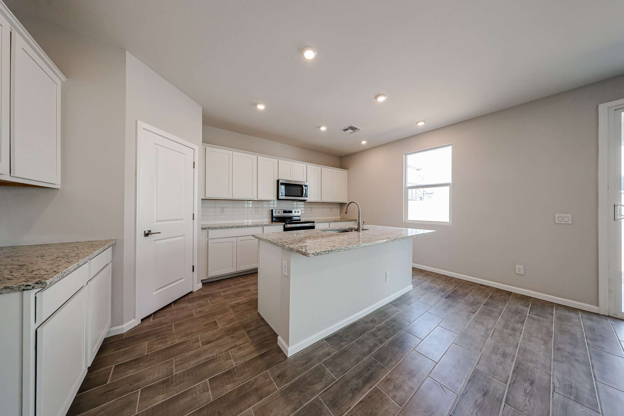 A kitchen with white cabinets.