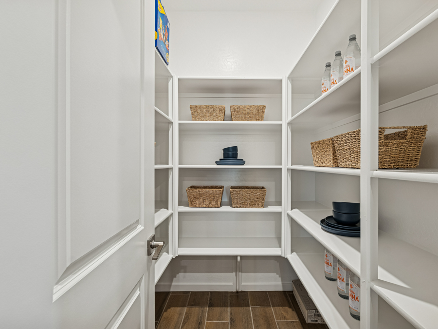 A white shelving unit with baskets and baskets.
