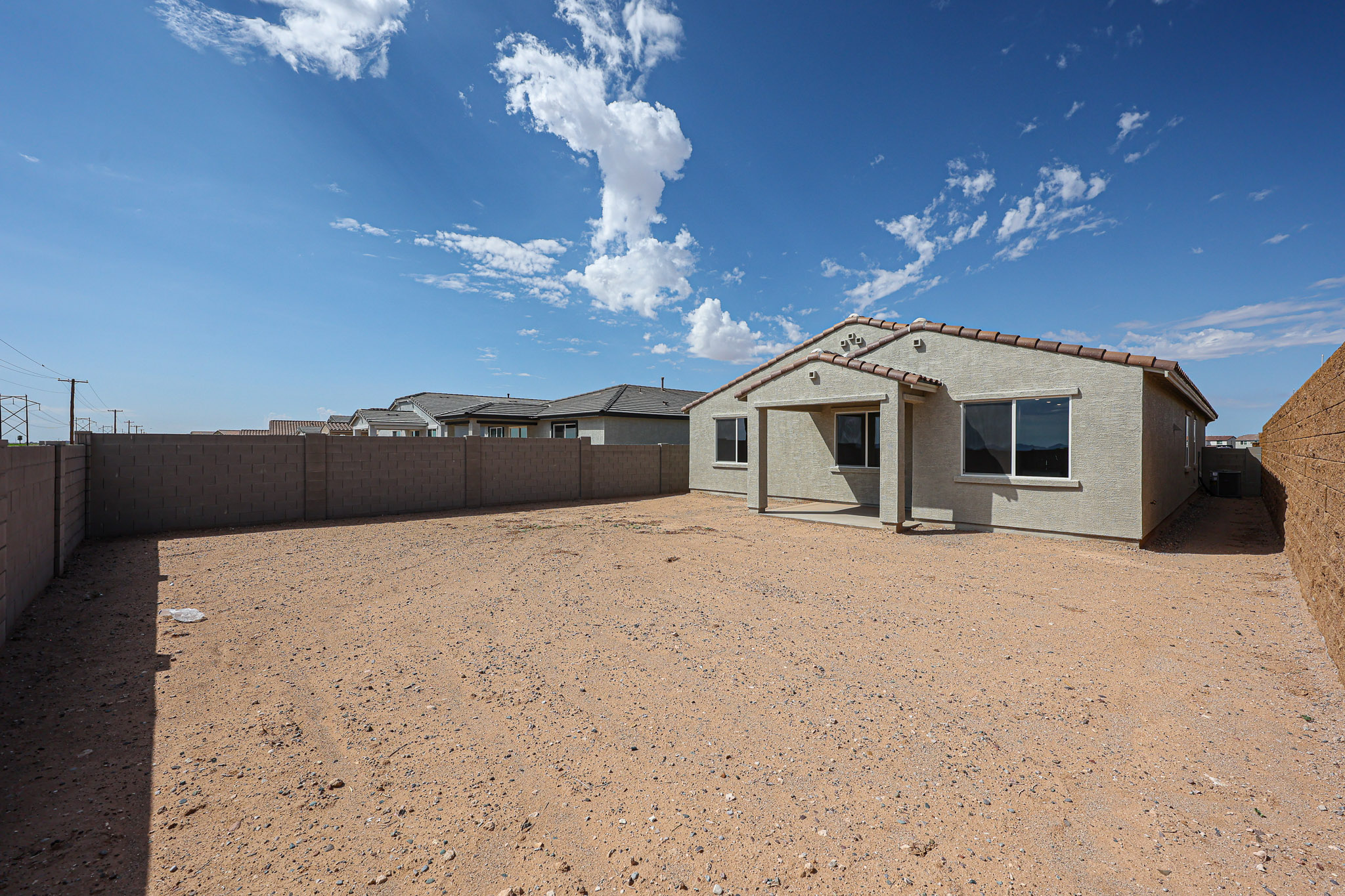 A dirt road with buildings on the side.