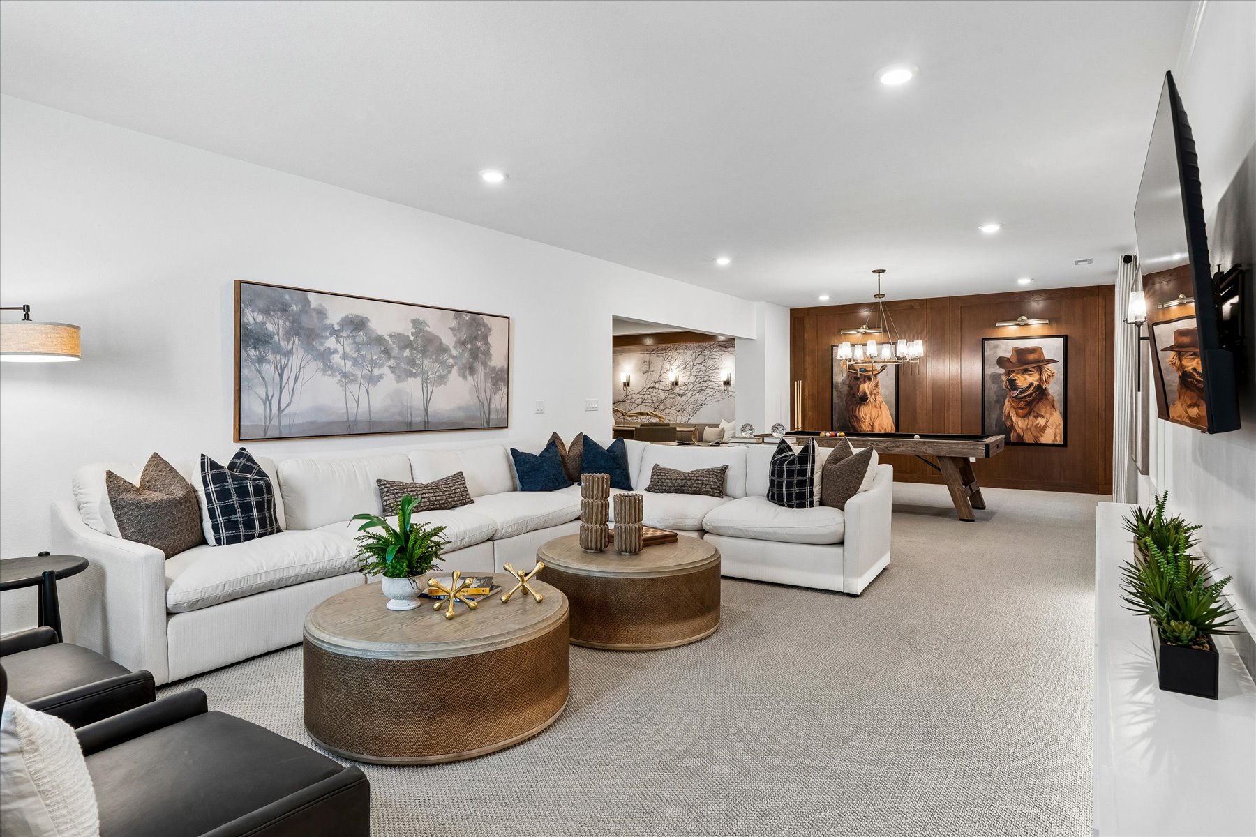 A living room with a white couch and a round coffee table.