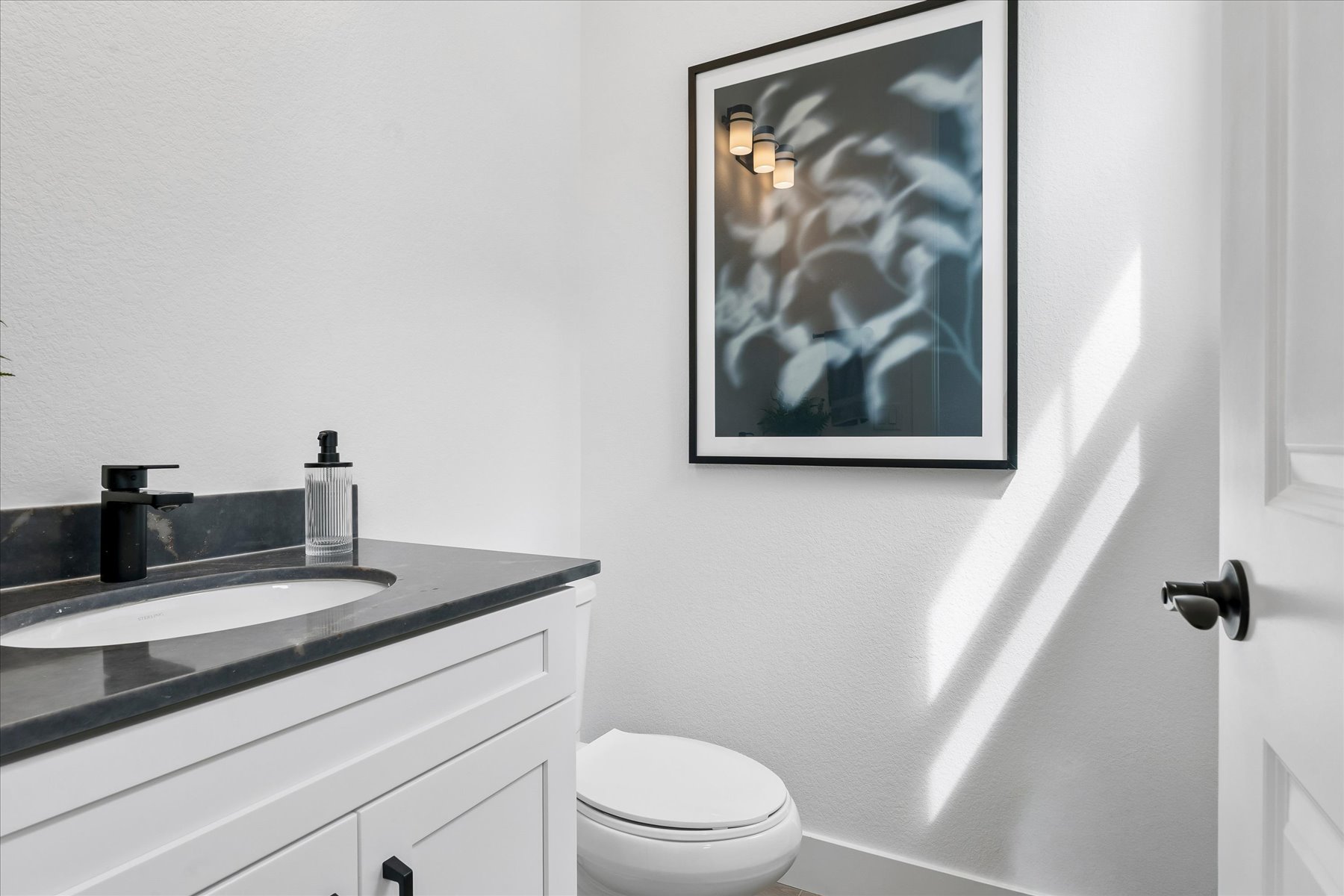 A bathroom with a picture on the wall.