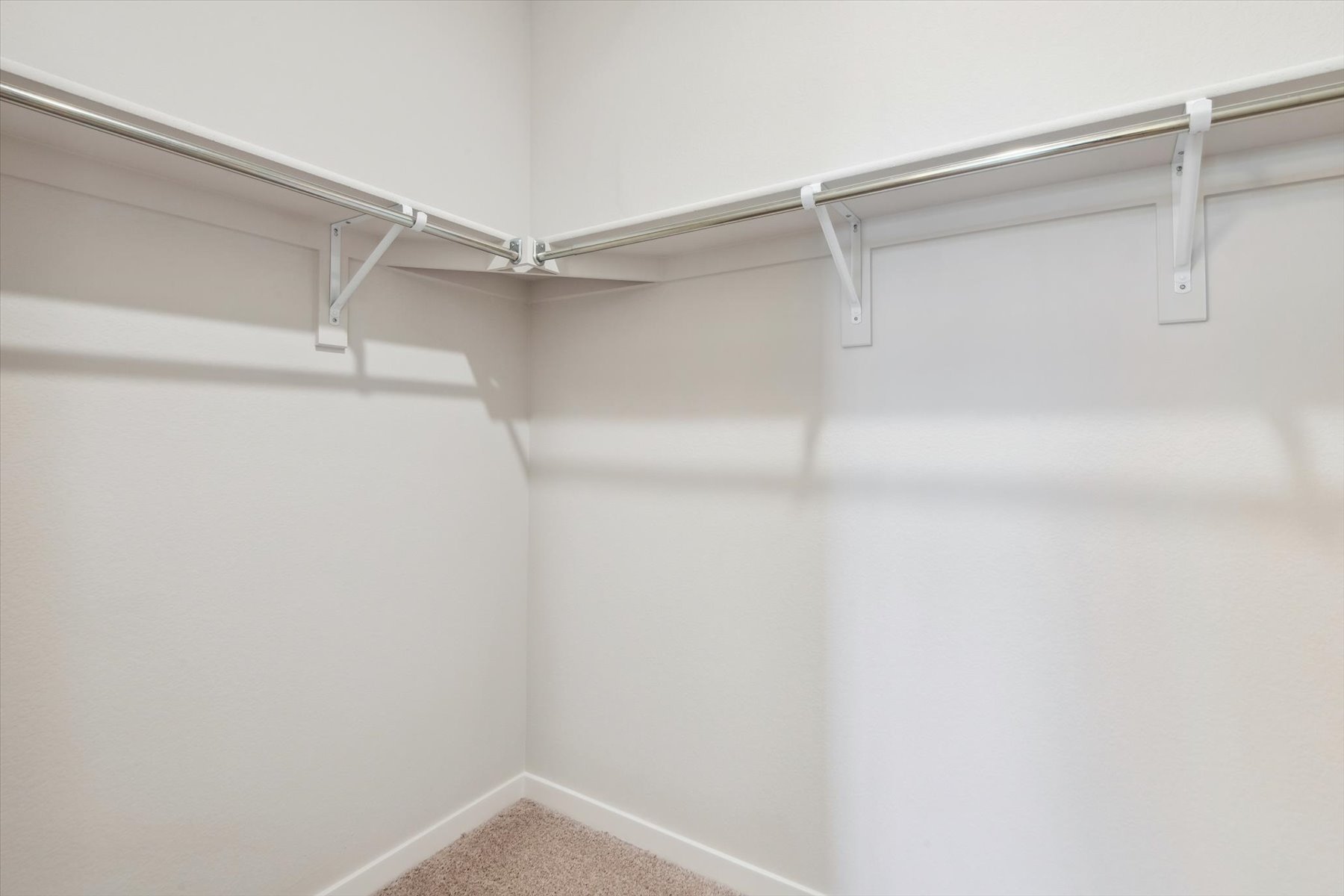 A white wall with a metal bar.