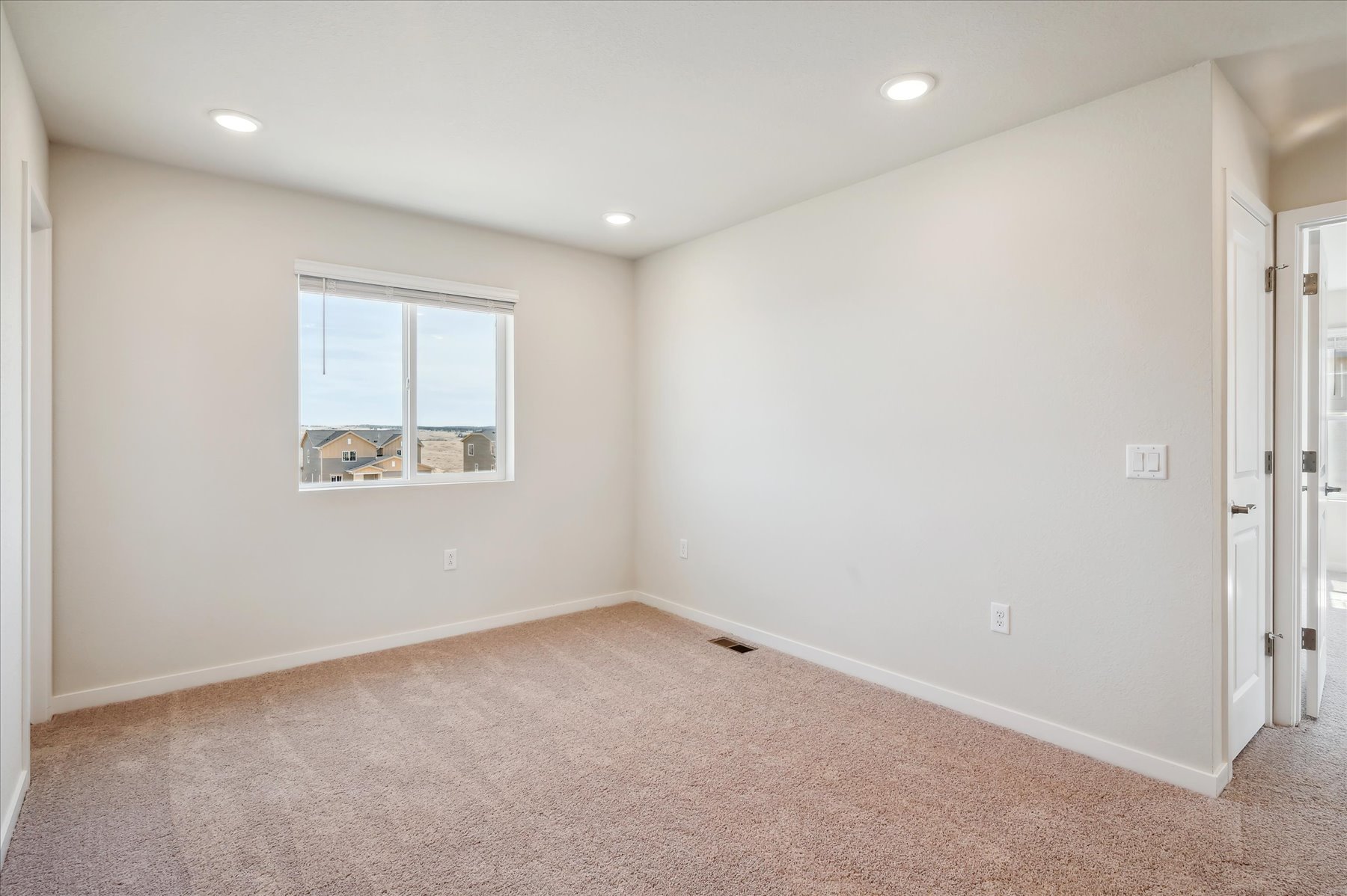 A room with a window and a carpet.