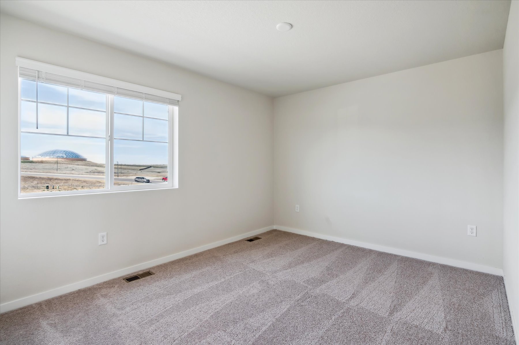 A room with a window and a carpet.