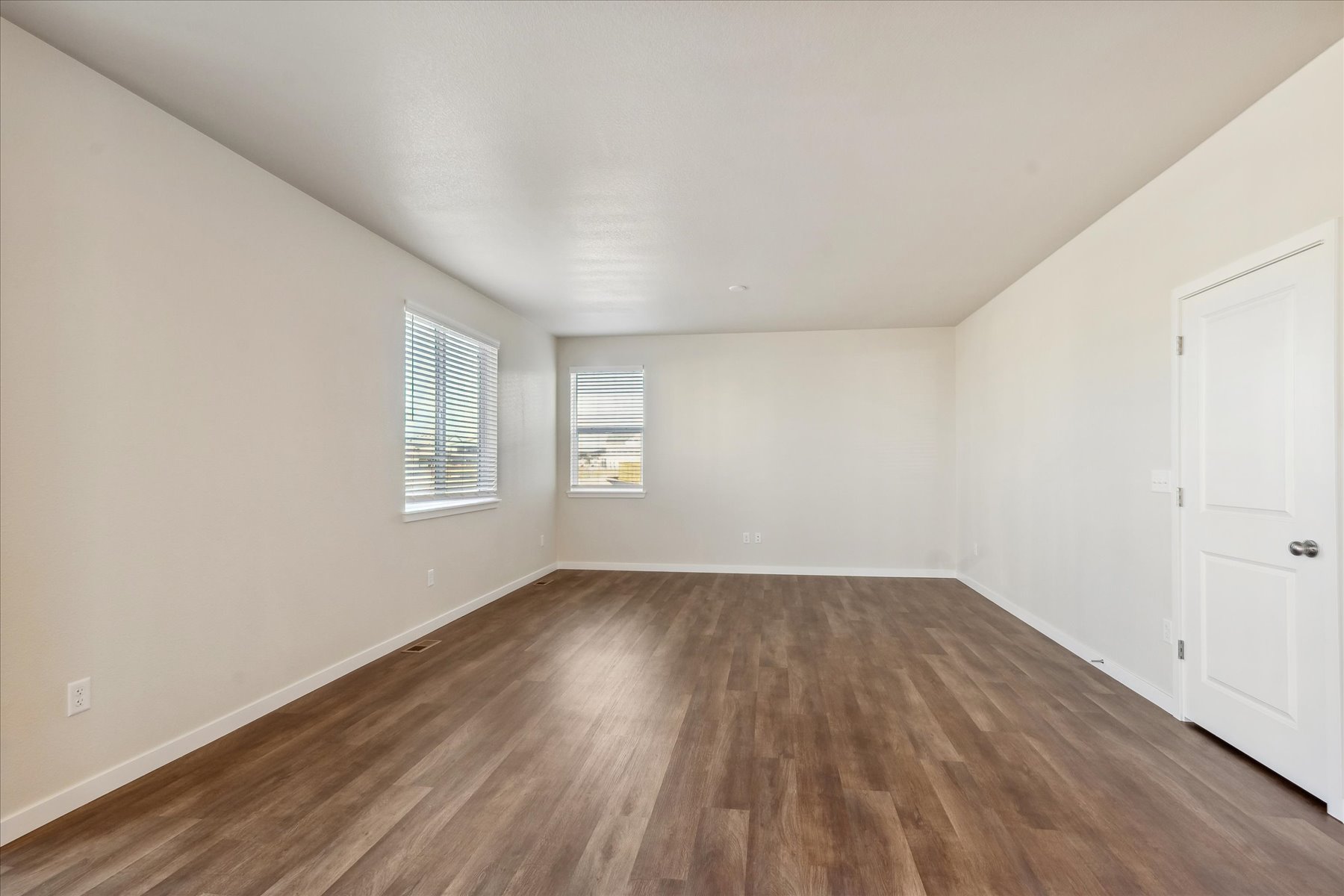 A room with white walls and a wood floor.