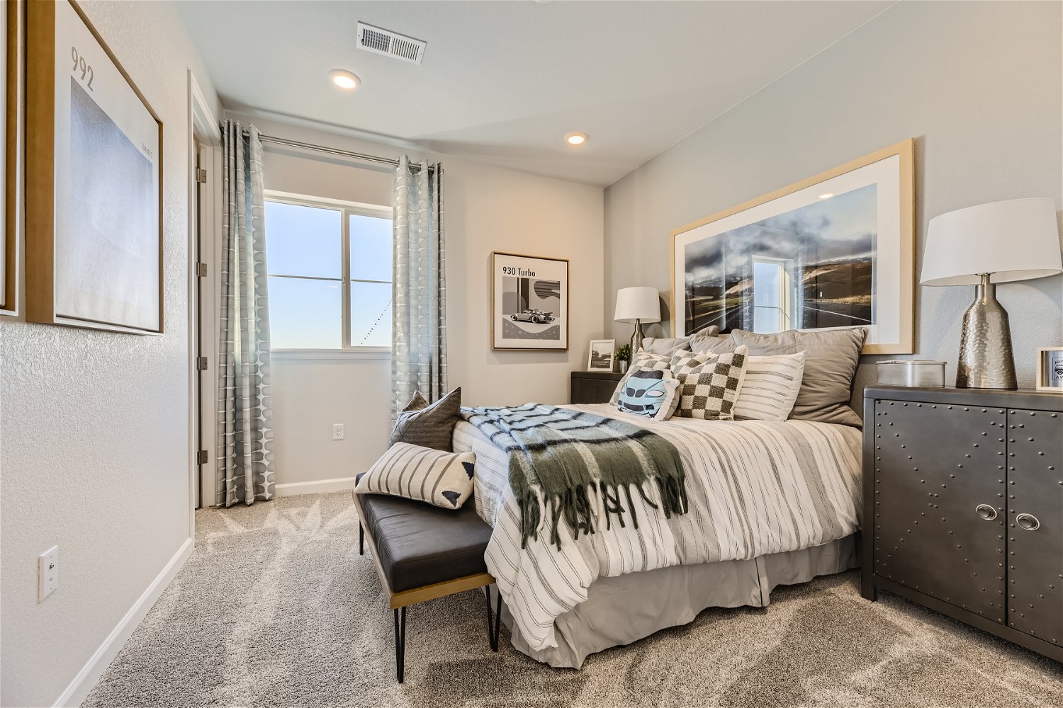 A bedroom with a bed and a bench.