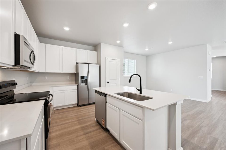 A kitchen with white cabinets.