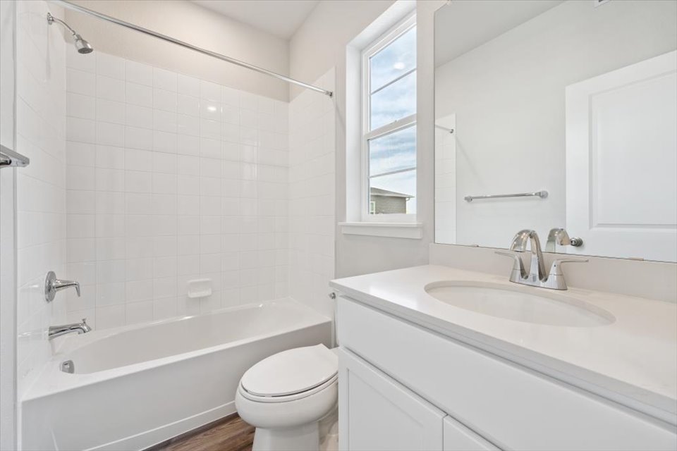 A bathroom with a tub sink and toilet.