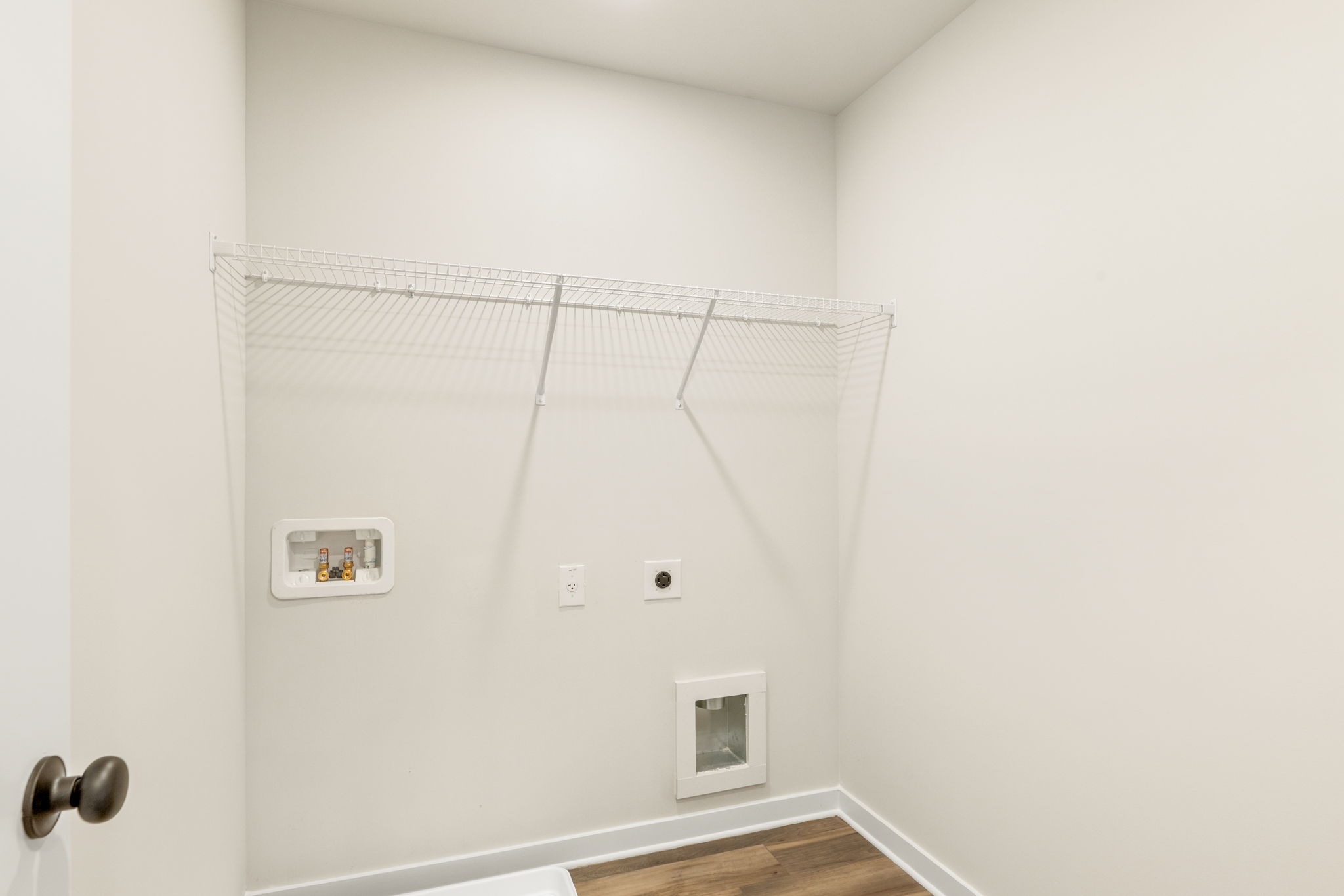 A white wall with a metal bar.