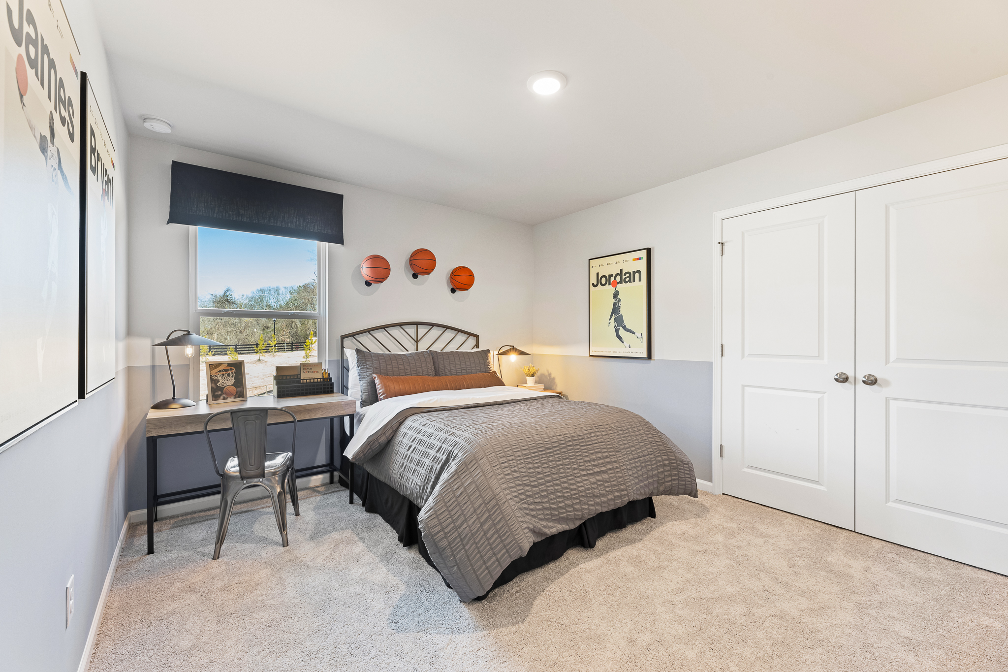 A bedroom with a bed desk and a chair.