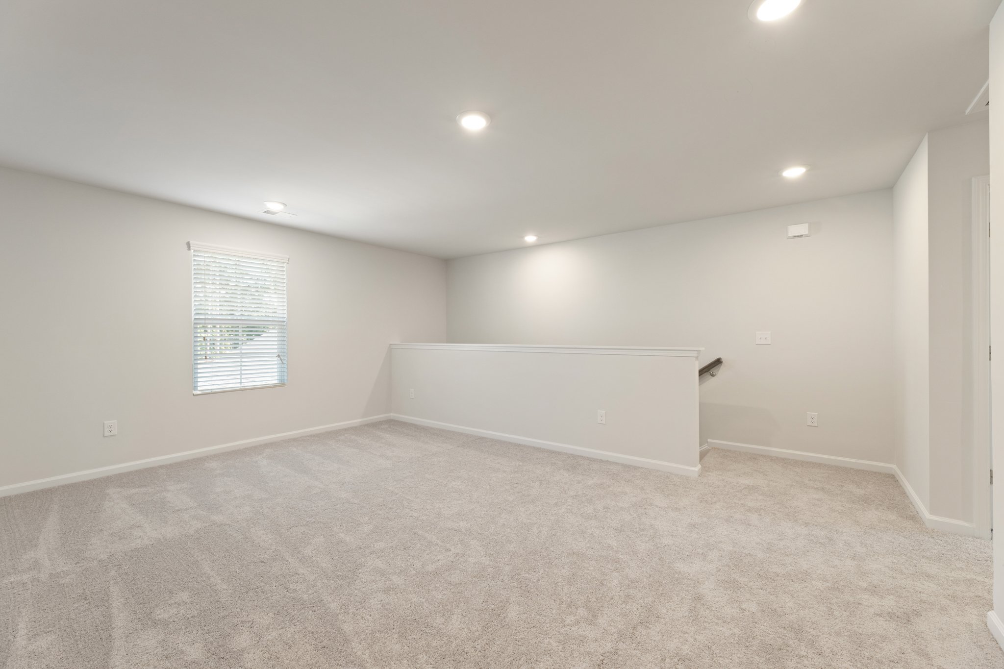 A room with a carpet and a white wall.