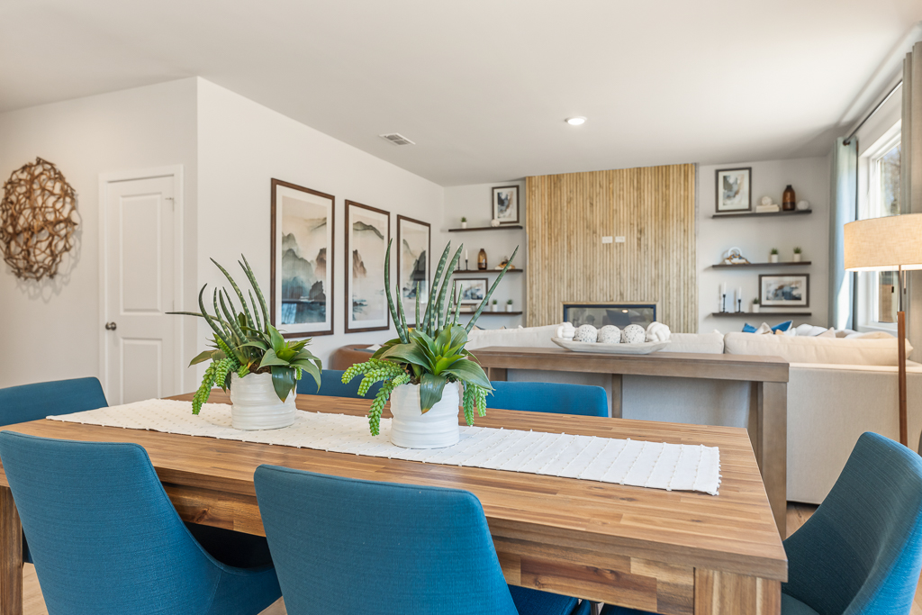 A dining room table with blue chairs.