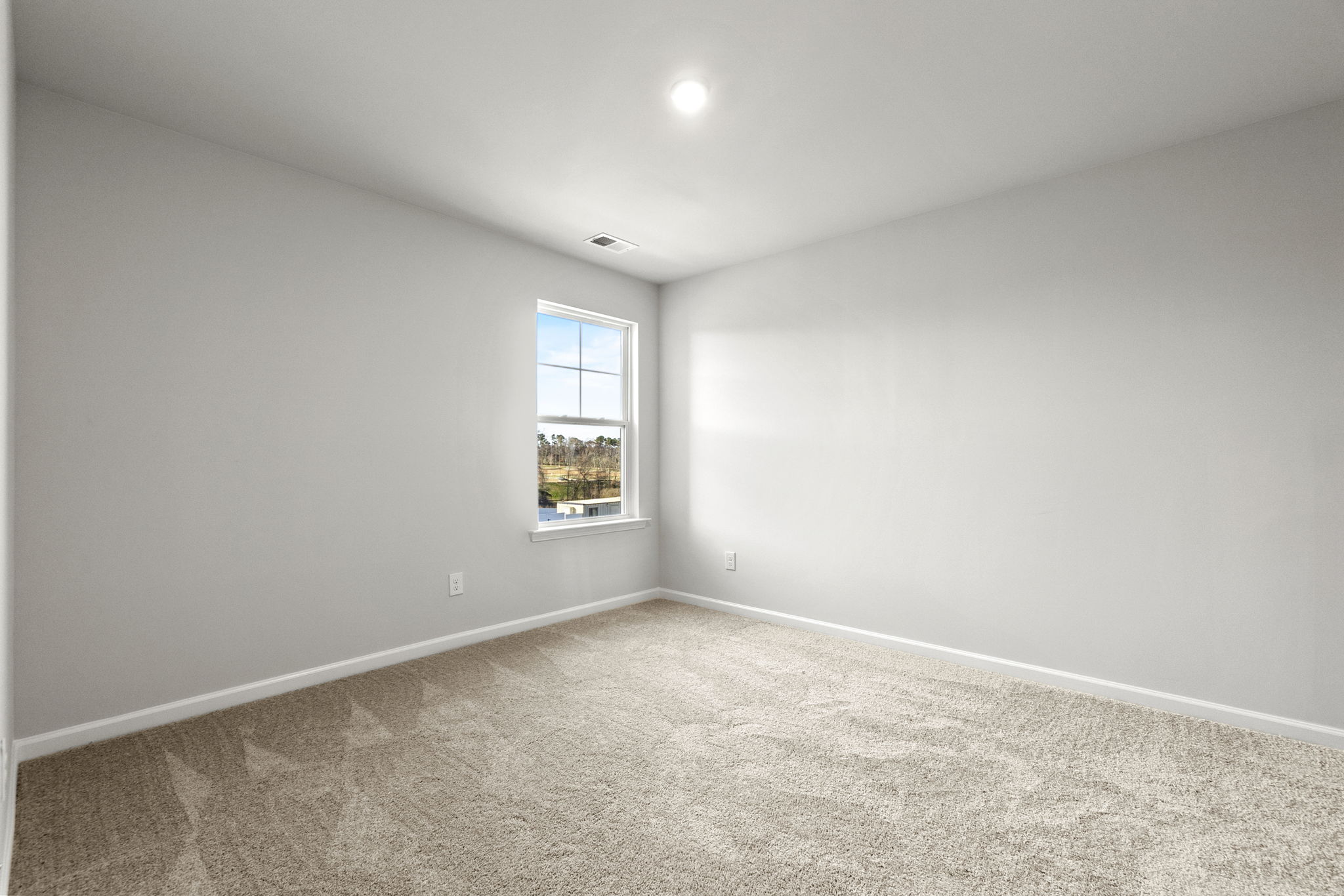 A room with a window and carpet.