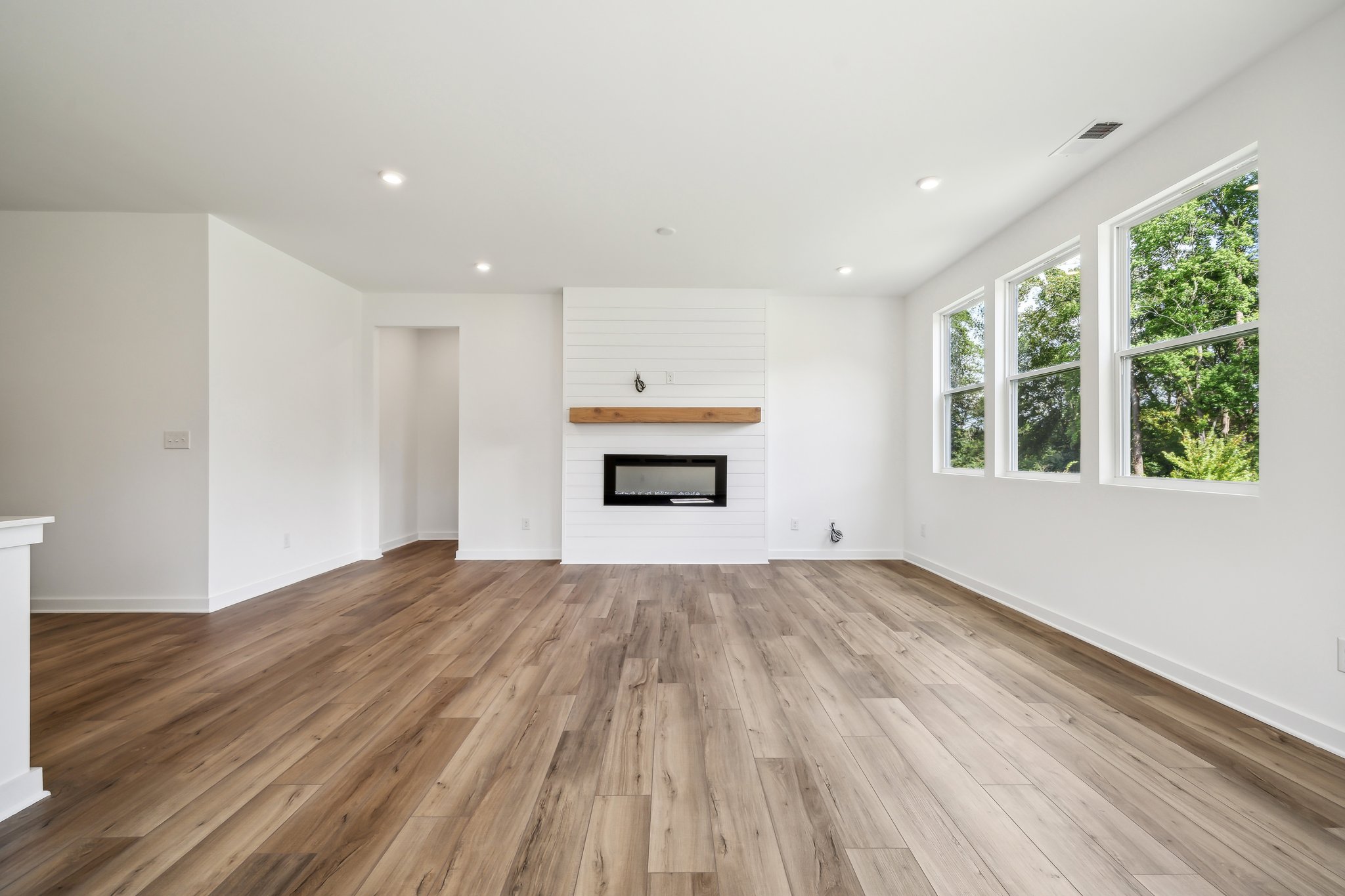 A room with a wood floor and a fireplace.