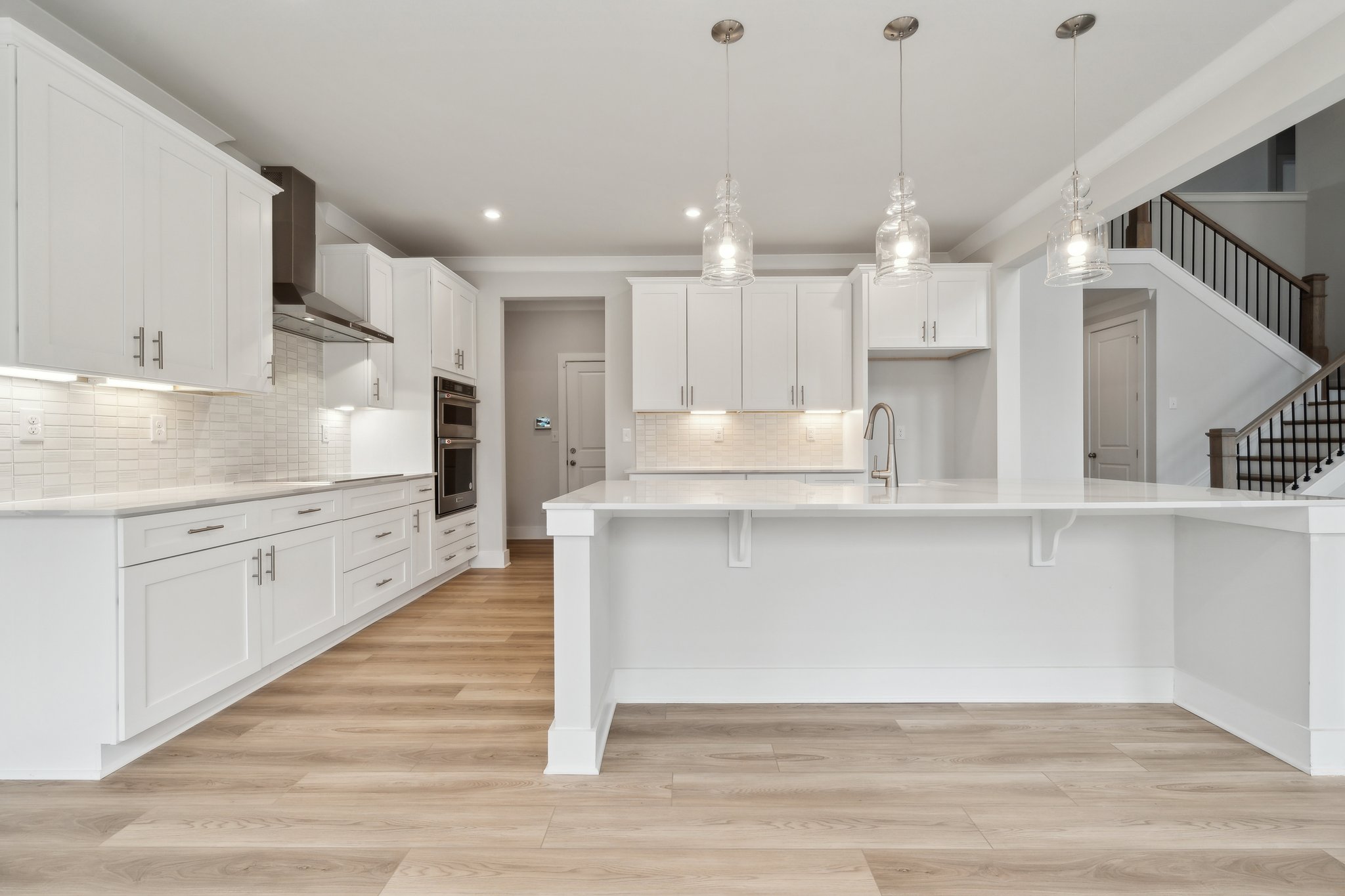 A kitchen with white cabinets.