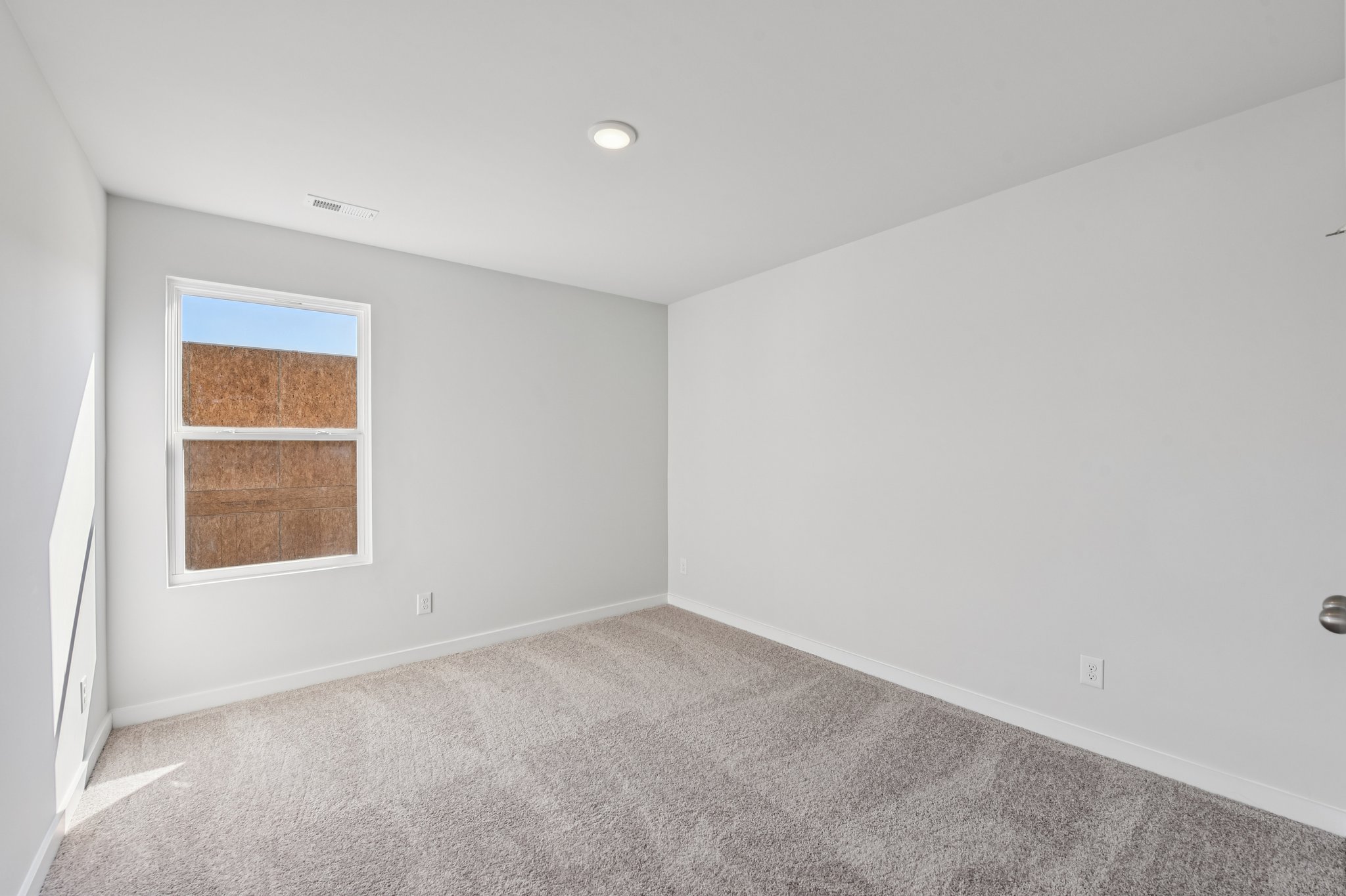 A room with a window and carpet.