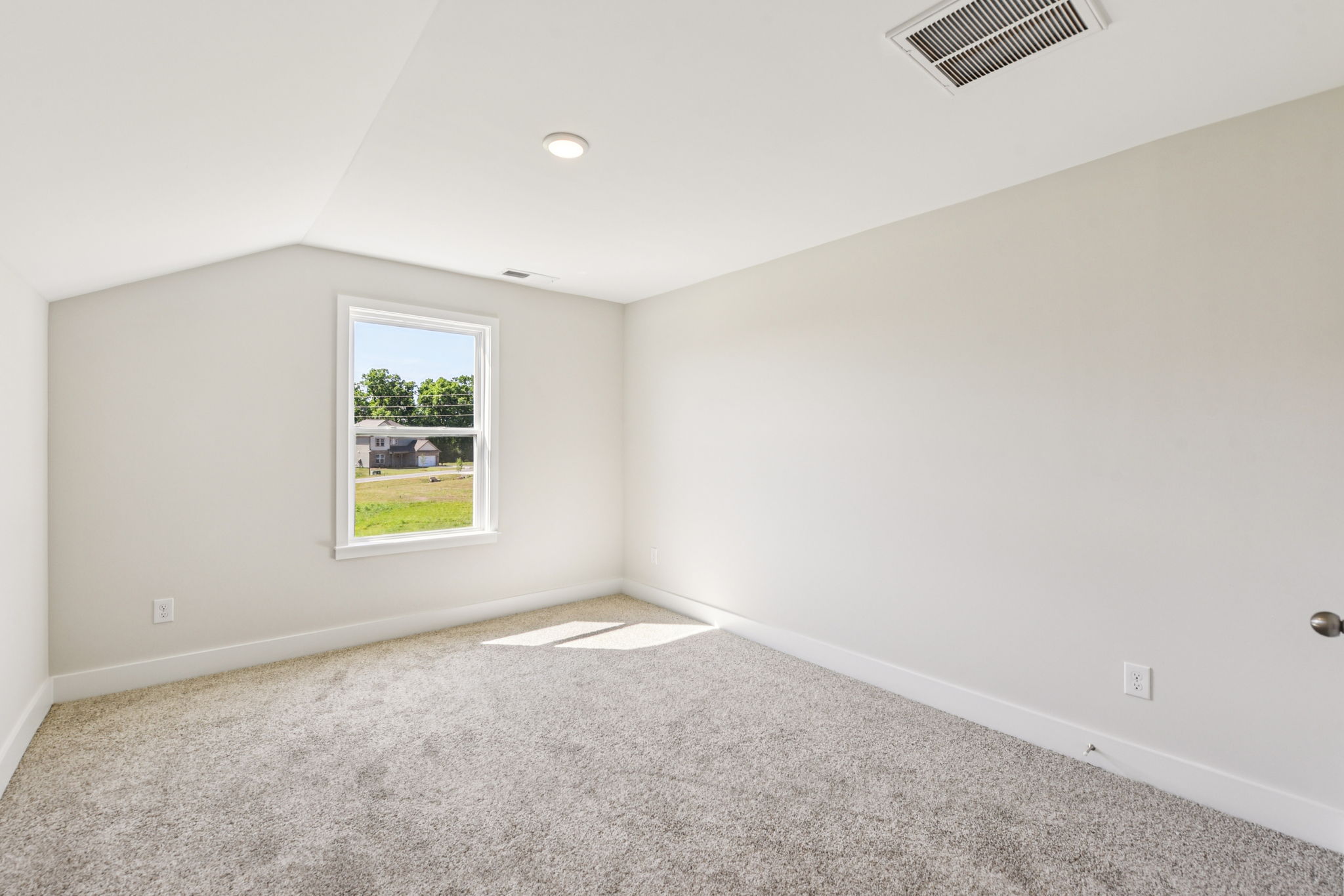 A room with a window and carpet.