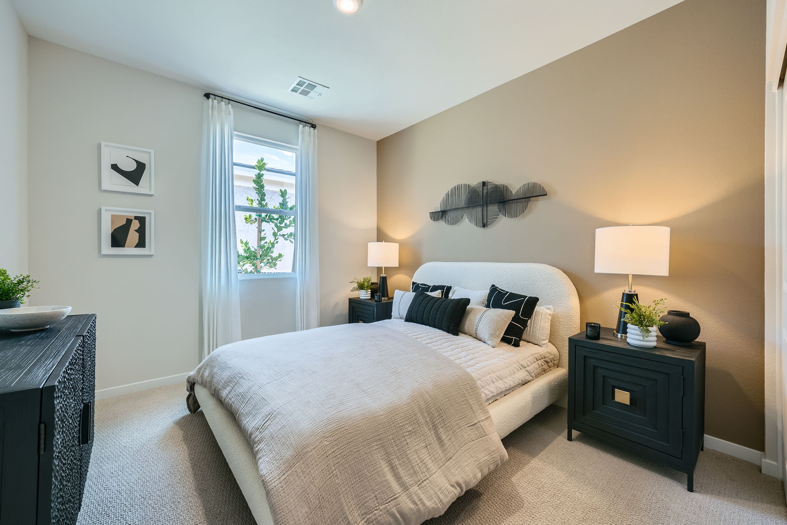 A bedroom with a bed and lamps.