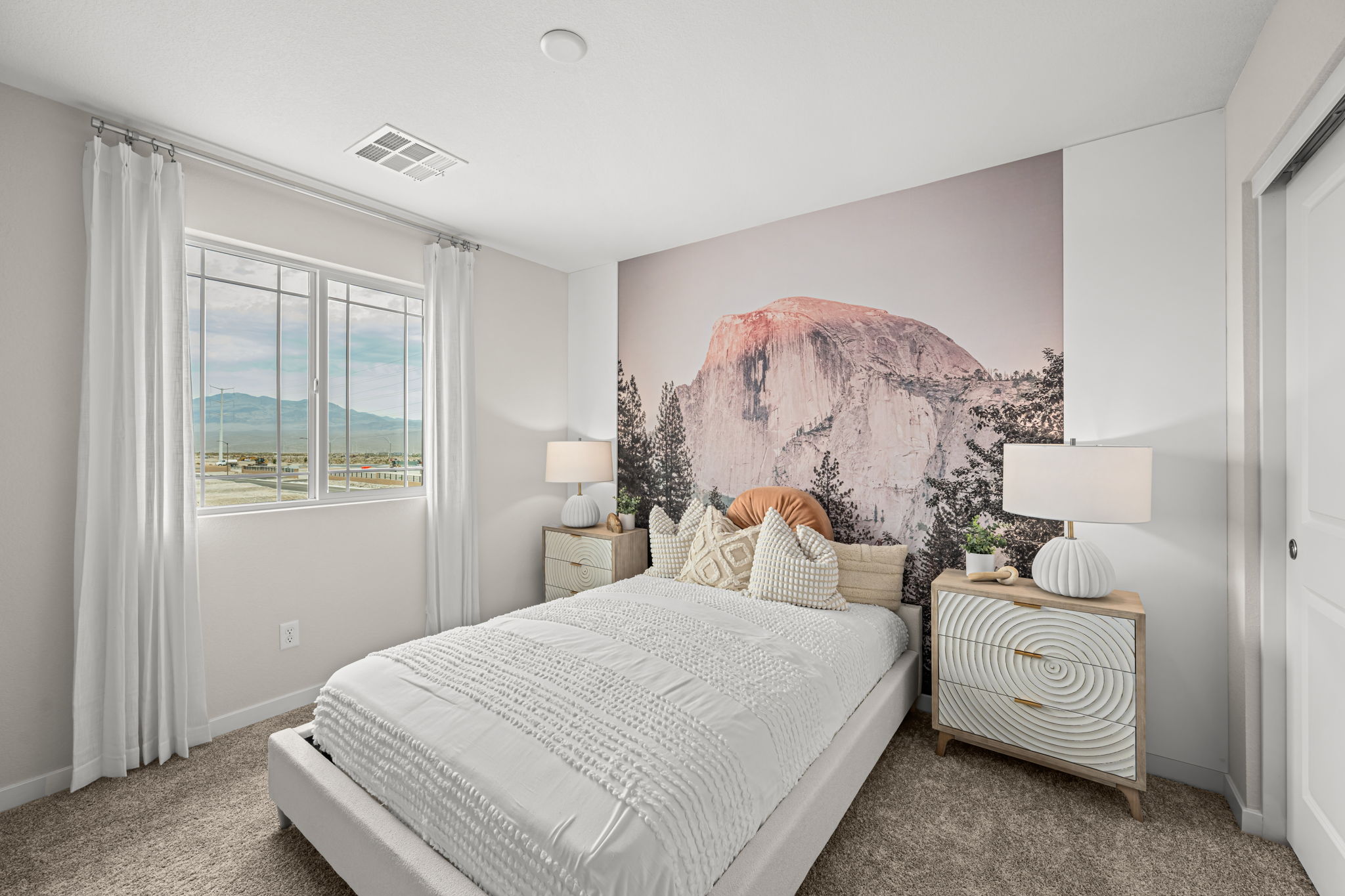 A bedroom with a bed and a lamp.