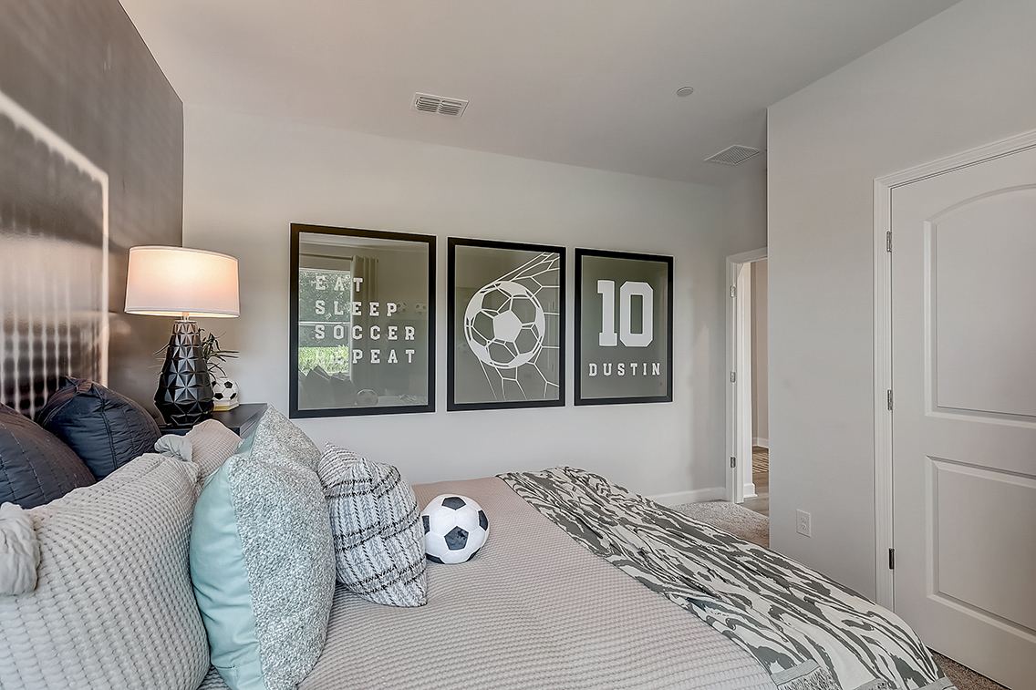 A bedroom with a bed and a lamp.