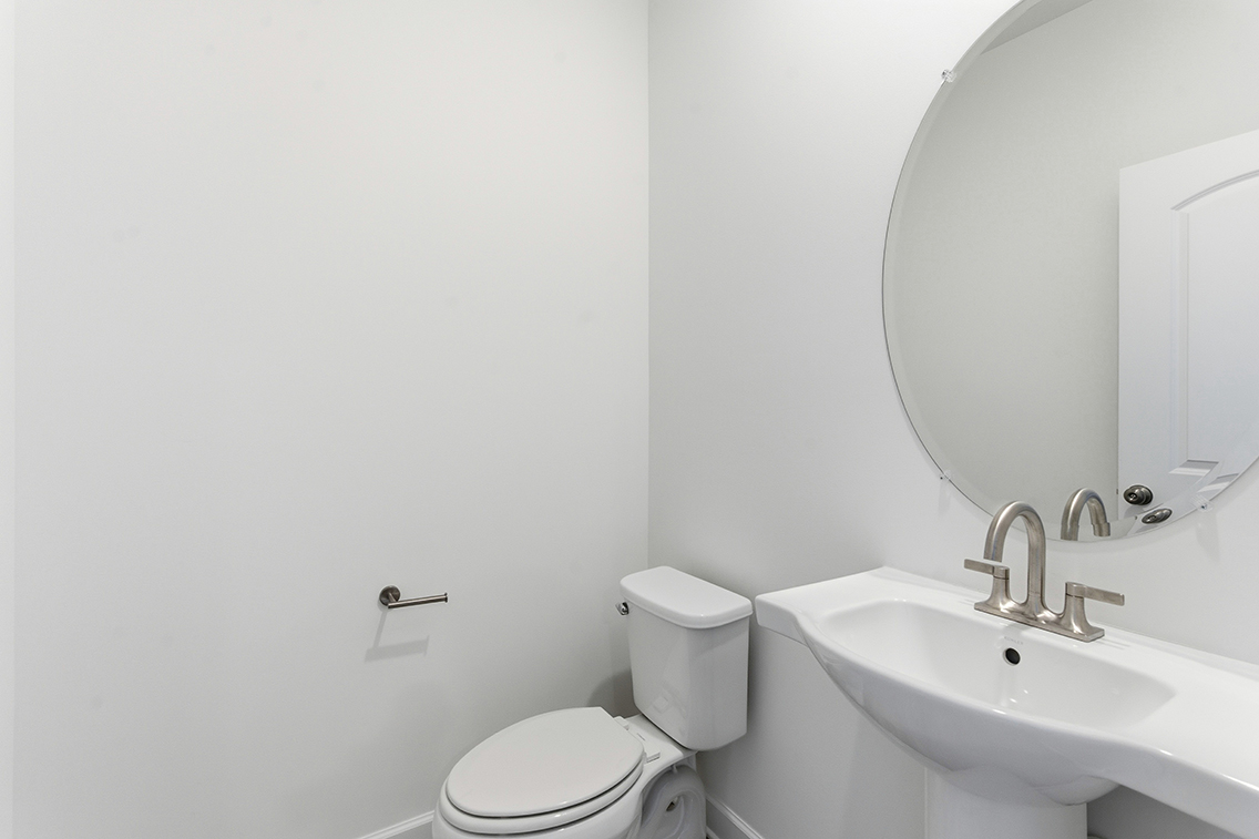 A bathroom with a round mirror.