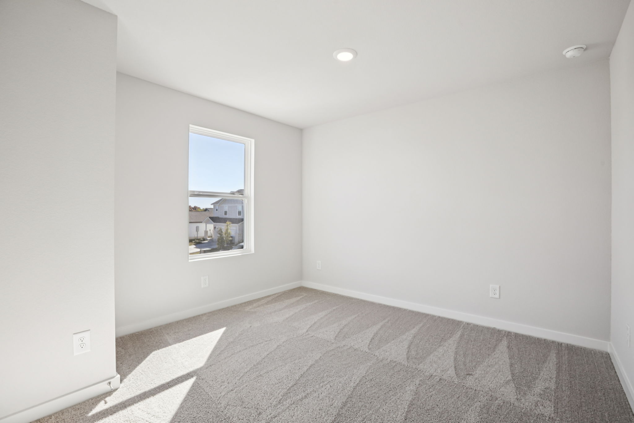 A room with a carpet and a window.