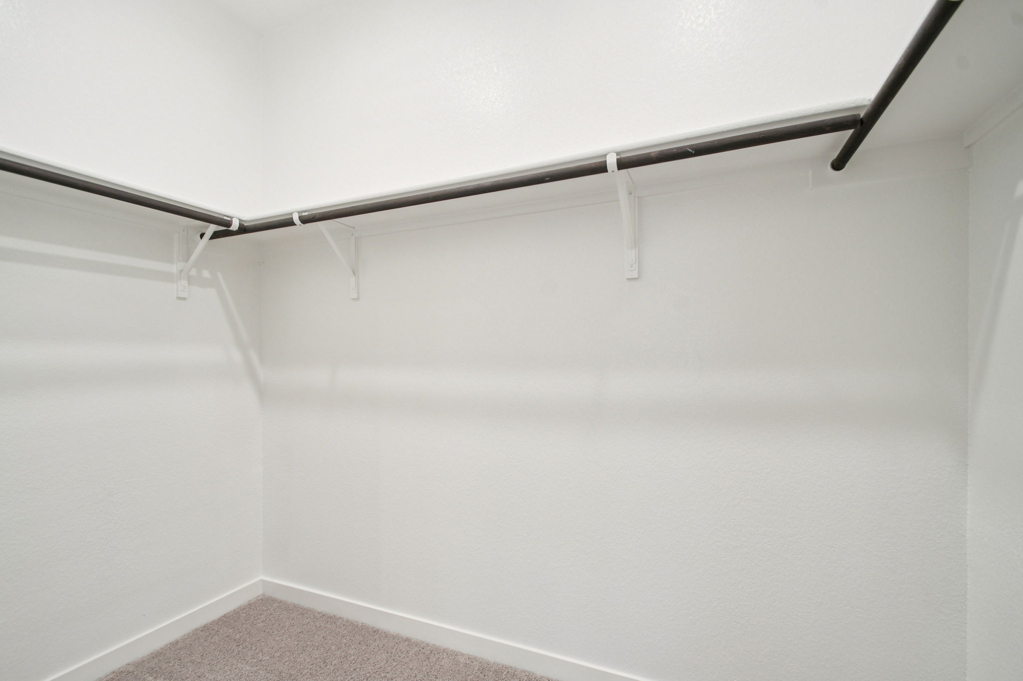 A white wall with a metal bar.