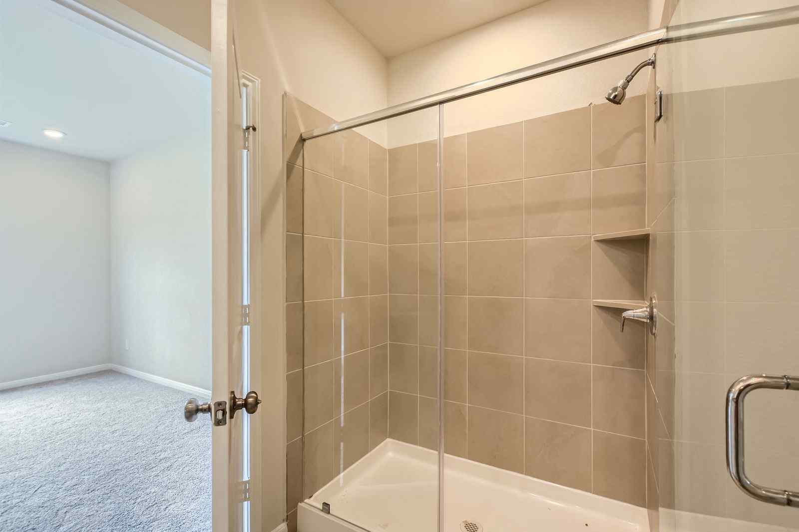 A bathroom with a shower unit and a bathtub.