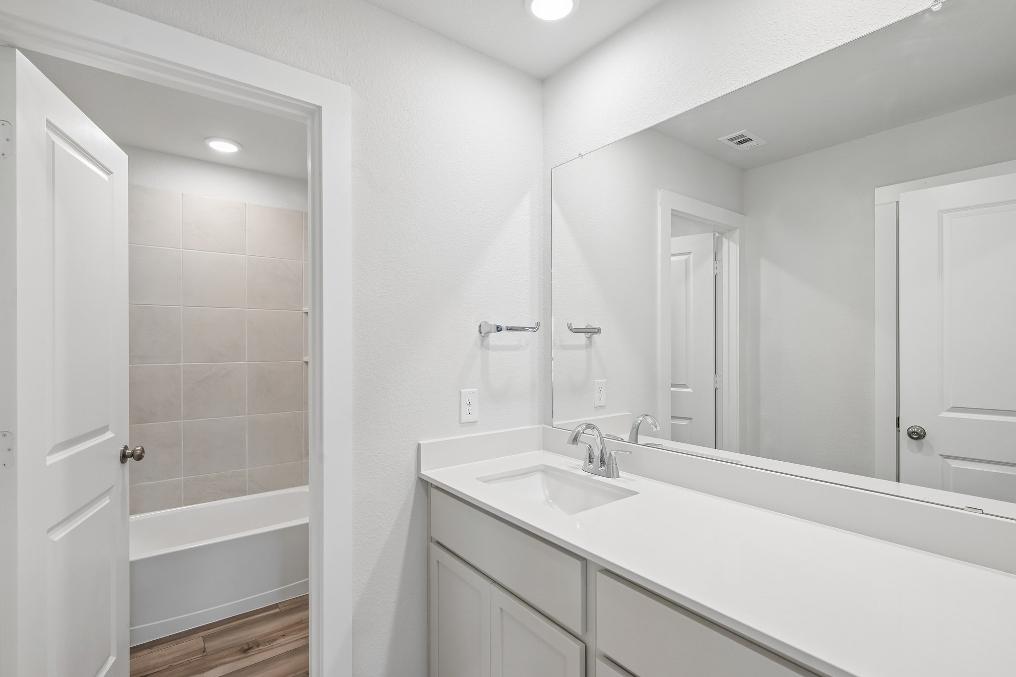 A bathroom with a sink and a shower unit.