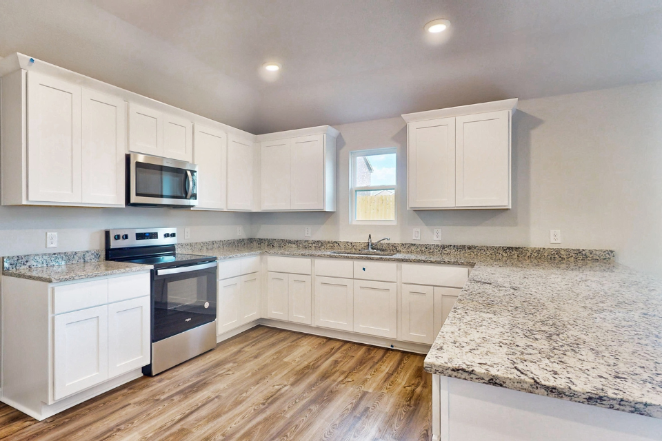 A kitchen with white cabinets.