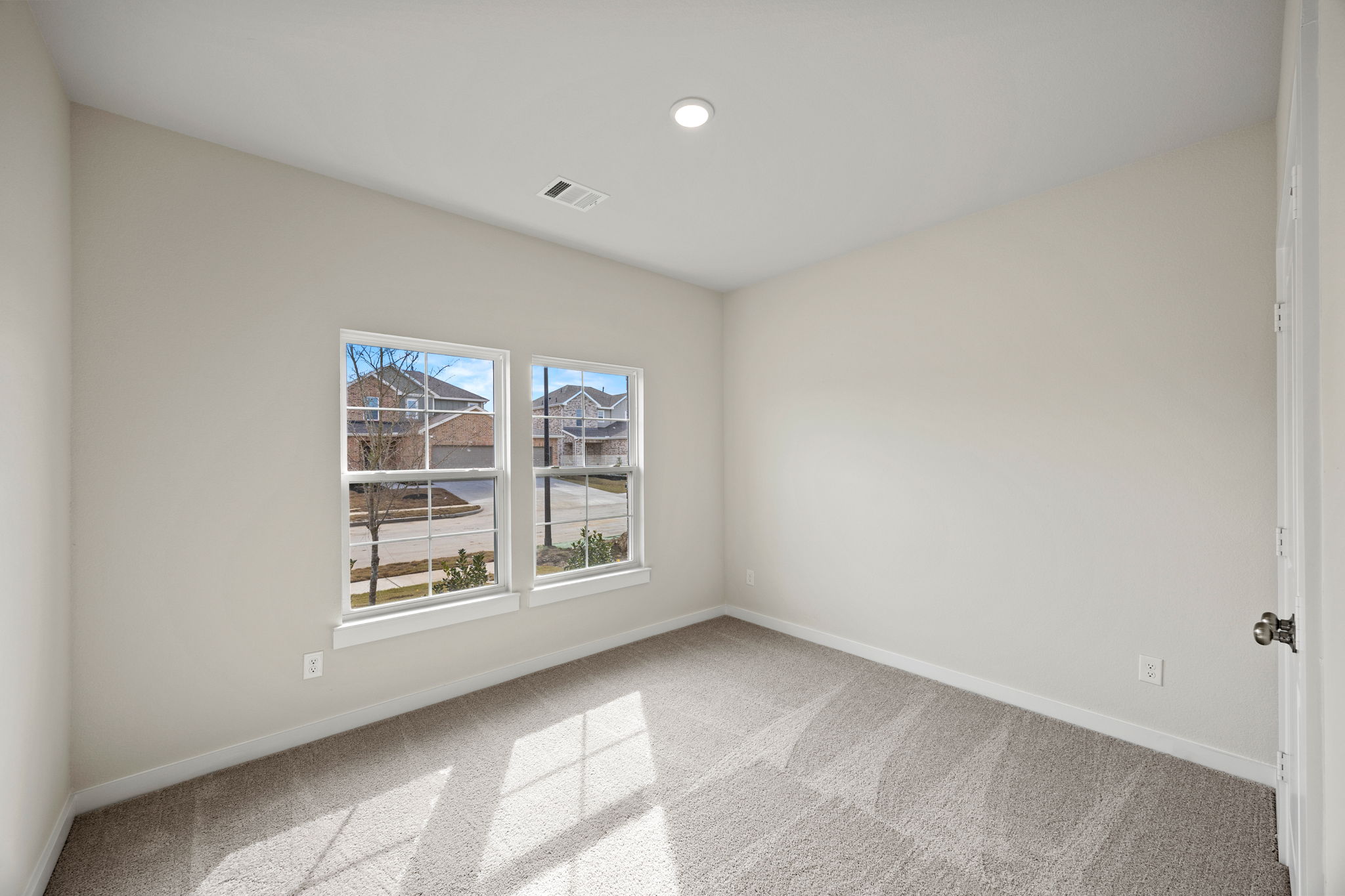 A room with a window and a rug.