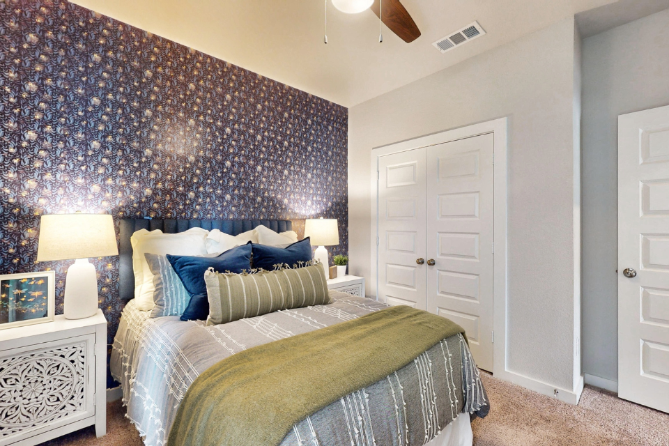 A bedroom with a bed and lamps.