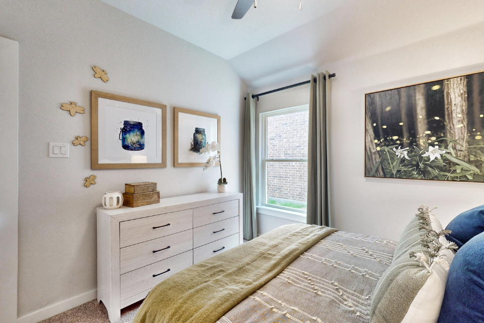 A bedroom with a bed and dresser.