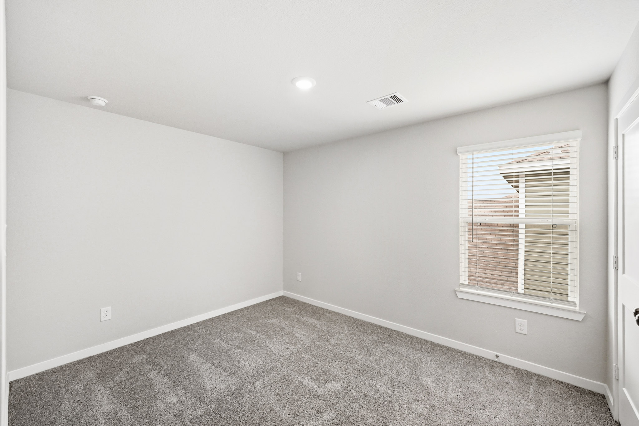 A room with a carpet and a window.