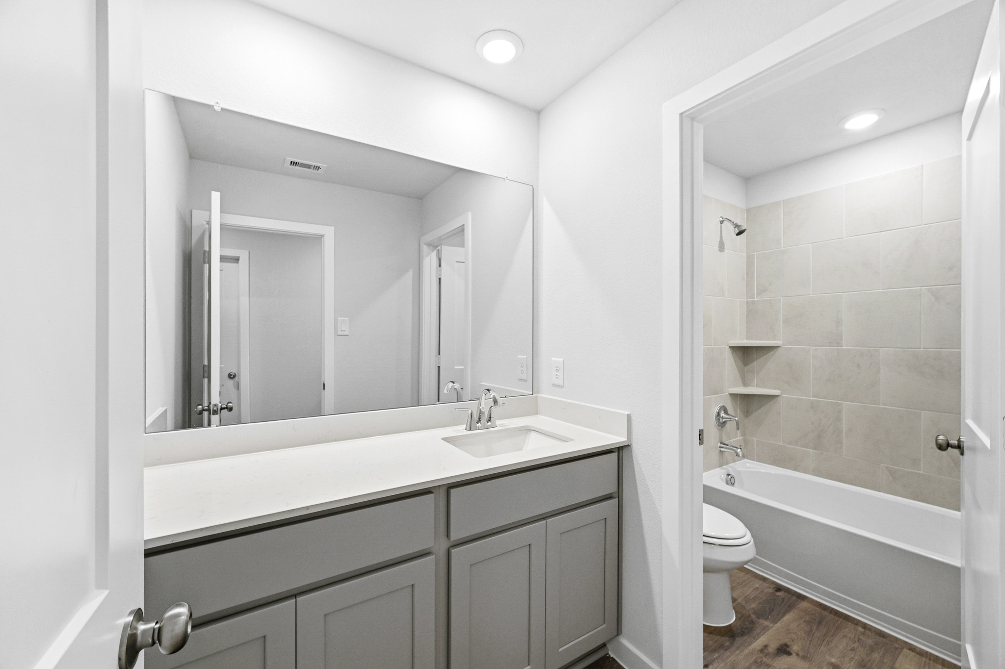 A bathroom with a large mirror.